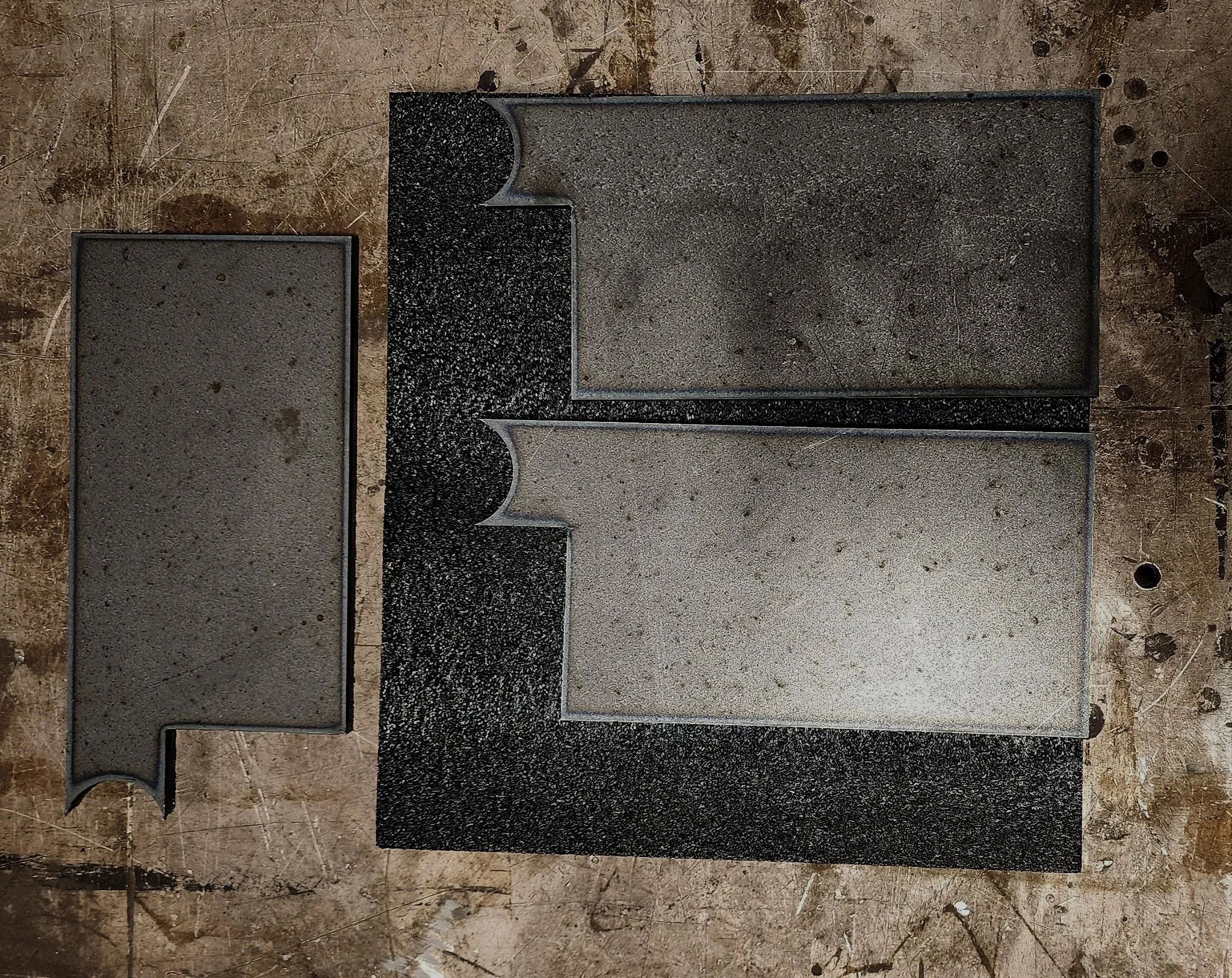 Various black and gray granite gravestones on a dirt ground.