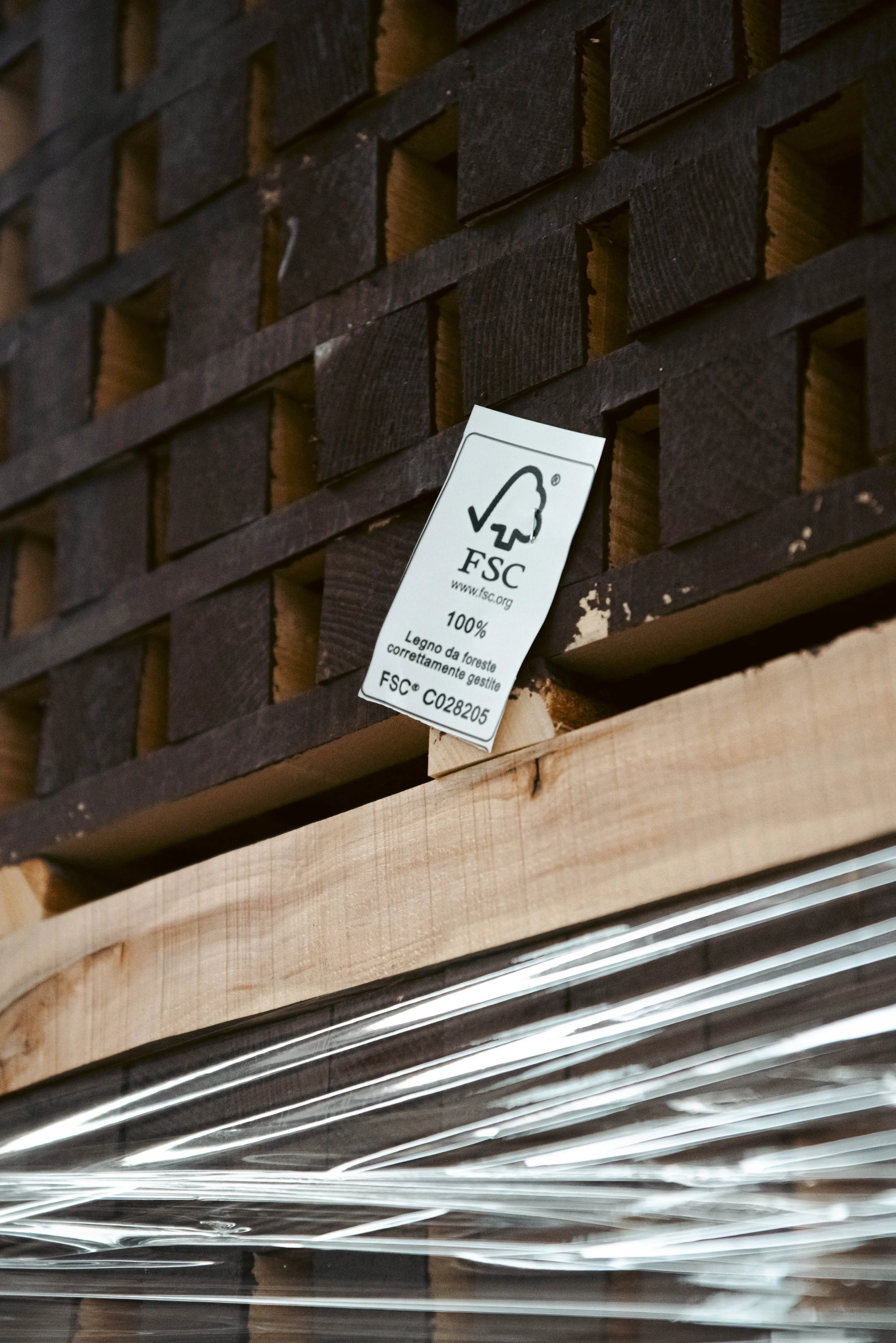 Close-up of a wooden structure with a label indicating FSC certification, with metal rods at the bottom.