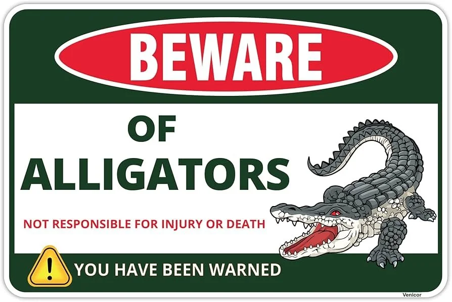 Warning sign with bold red and green text reading "Beware of Alligators" and a picture of an alligator, warning of danger and liability.