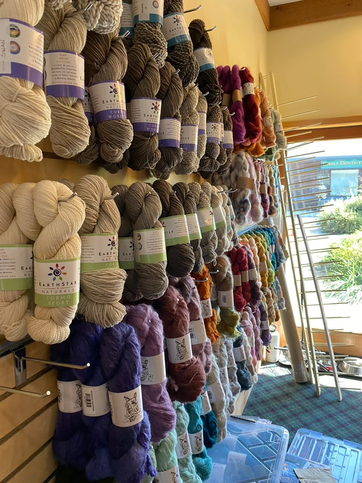 Wall display of hand-dyed yarn skeins in Old Sun Knits' Whitefish, Montana shop