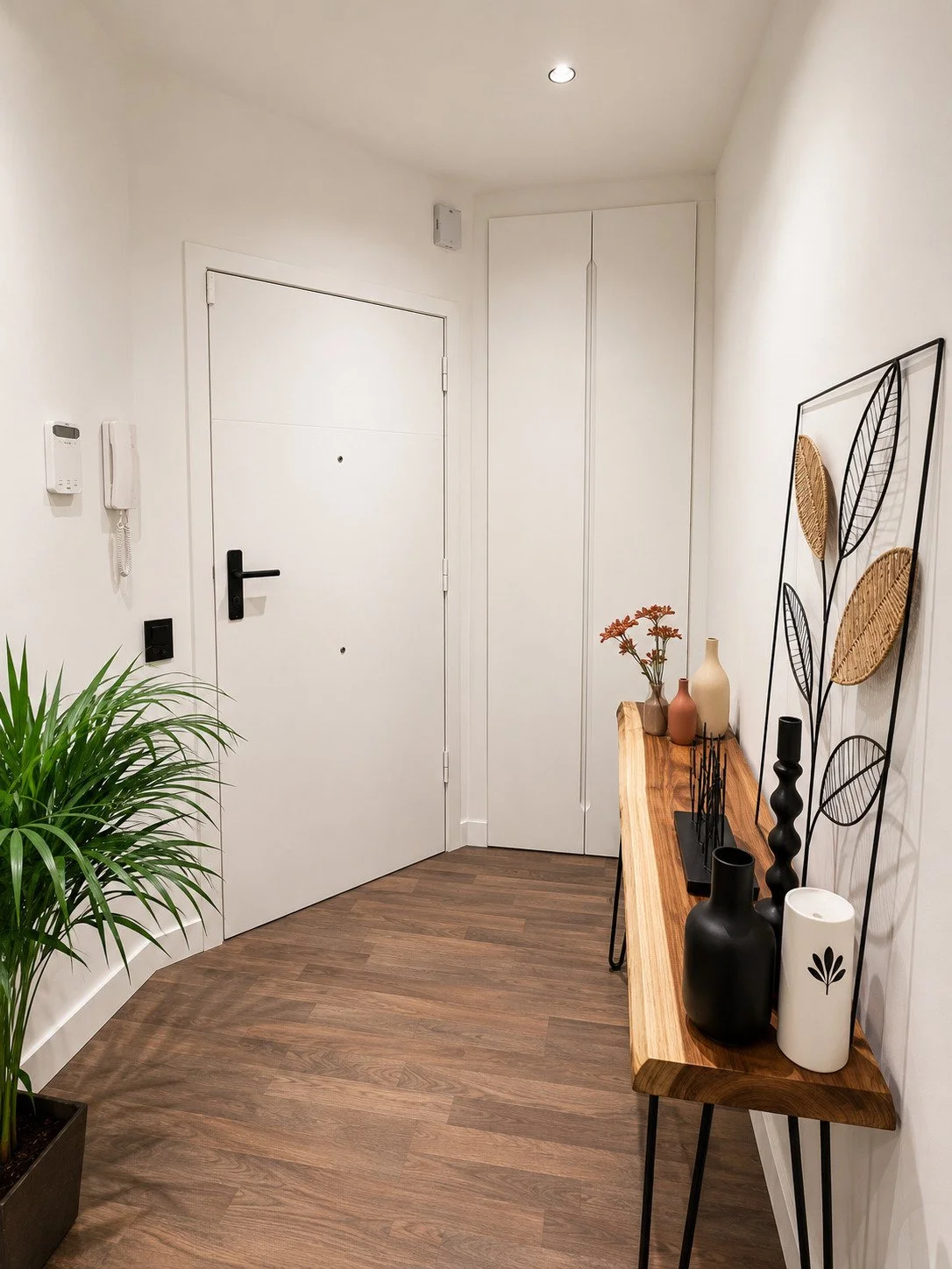 Reforma integral del recibidor con nuevos suelos, pintura, iluminación y acabados modernos realizada por Reformas Barna Decor.