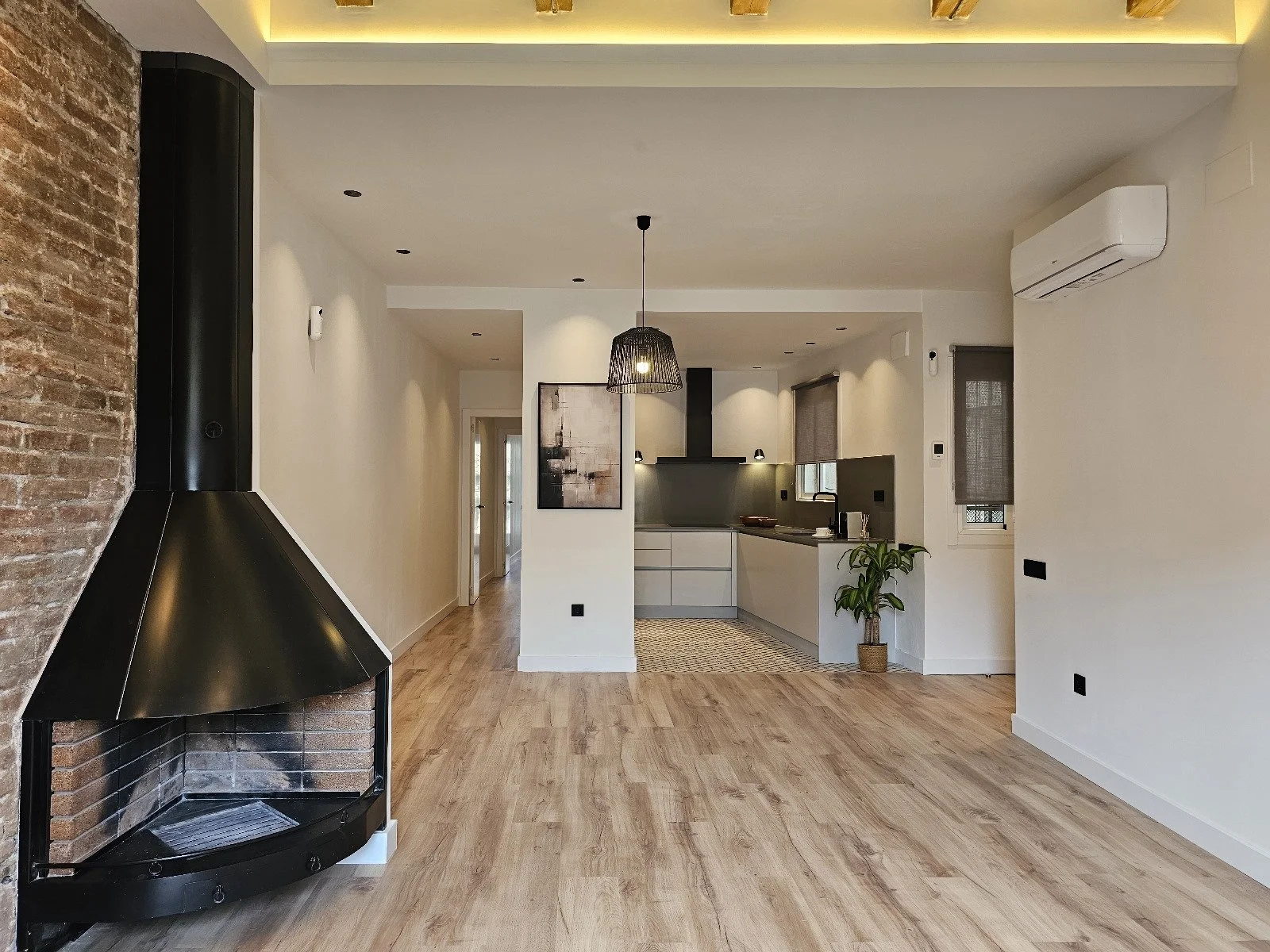 Proyecto de reforma integral de vivienda en Barcelona con redistribución de espacios, renovación de instalaciones, iluminación y acabados contemporáneos.