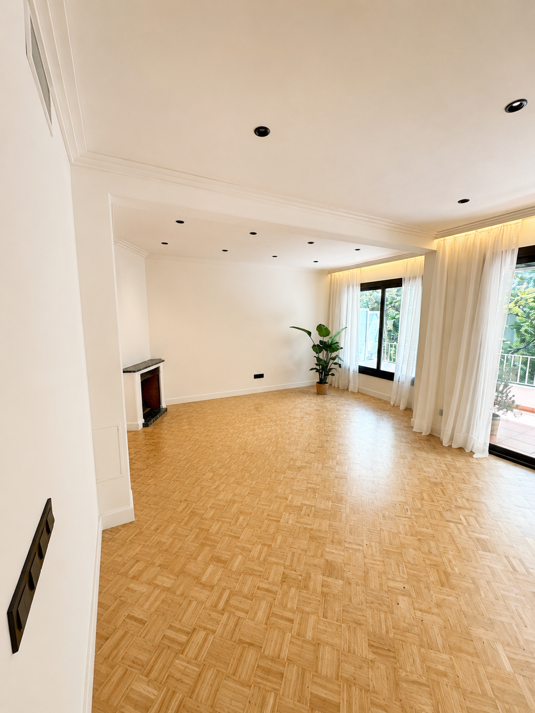 Reforma integral de salón con renovación de suelos, iluminación, pintura y acabados contemporáneos realizada por Reformas Barna Decor en Barcelona.