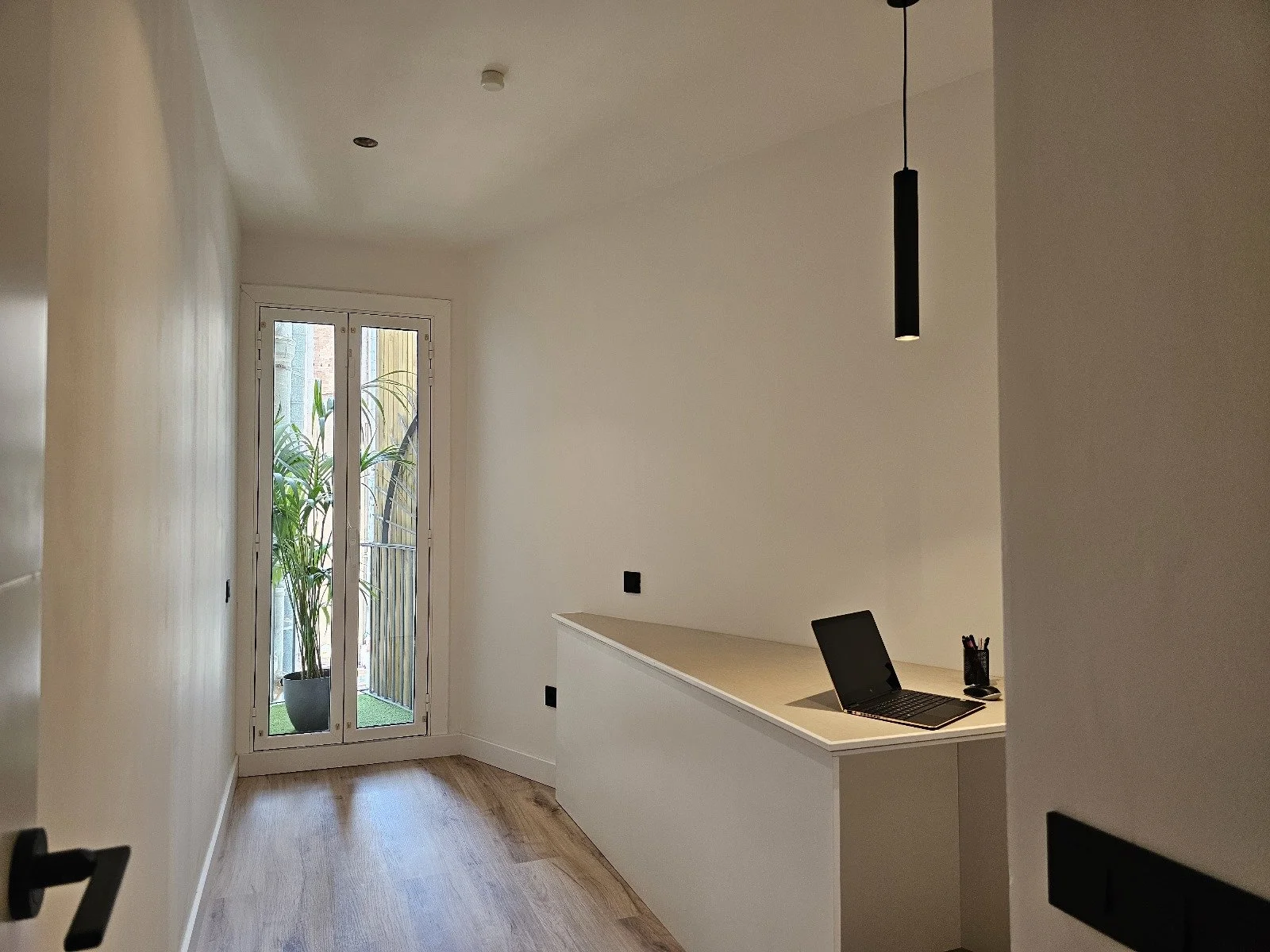 Reforma de despacho en vivienda con carpintería a medida, iluminación integrada y acabados contemporáneos realizada en Barcelona