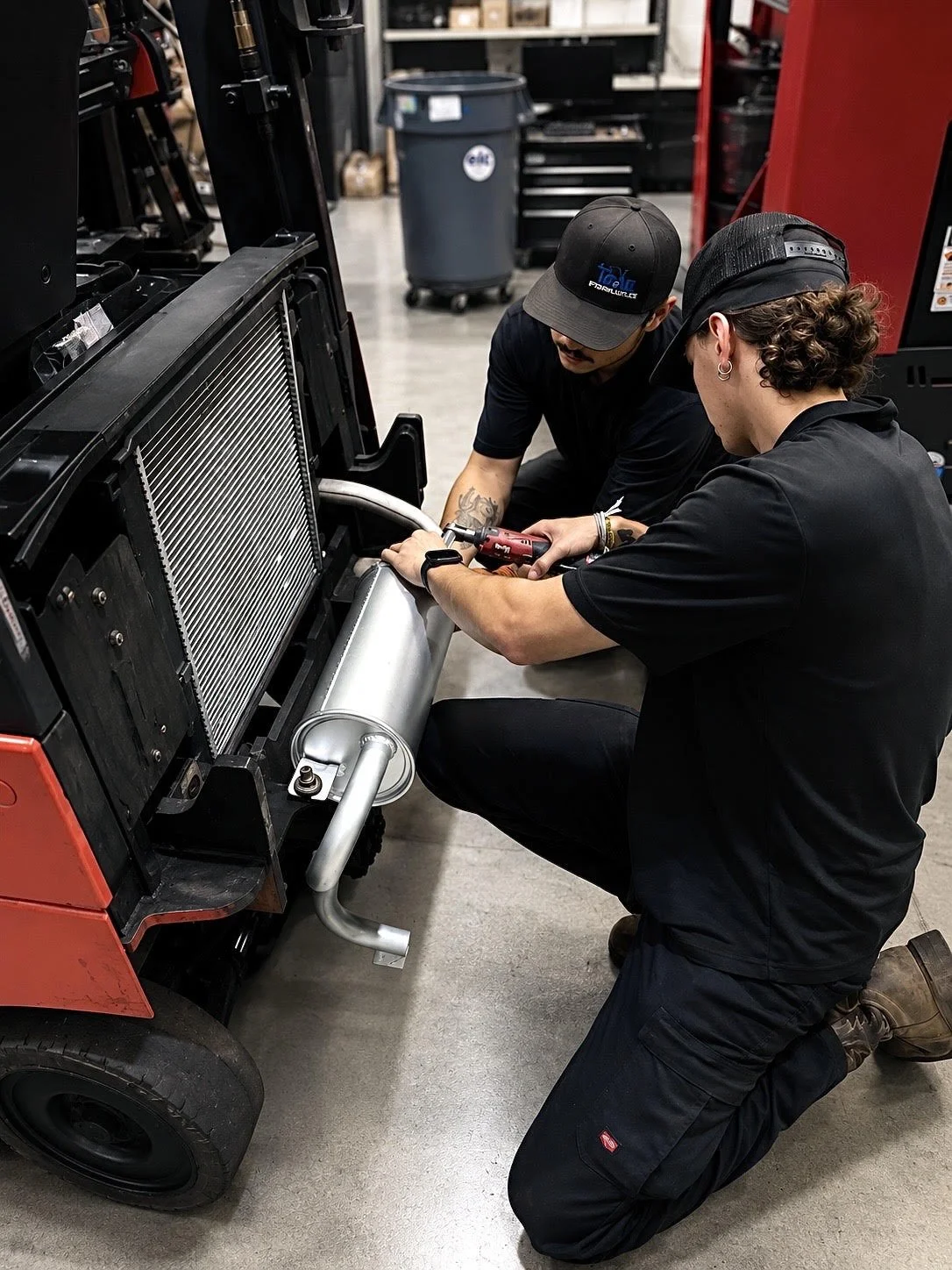 Certified forklift technicians repairing engine and muffler in Toyota forklift.