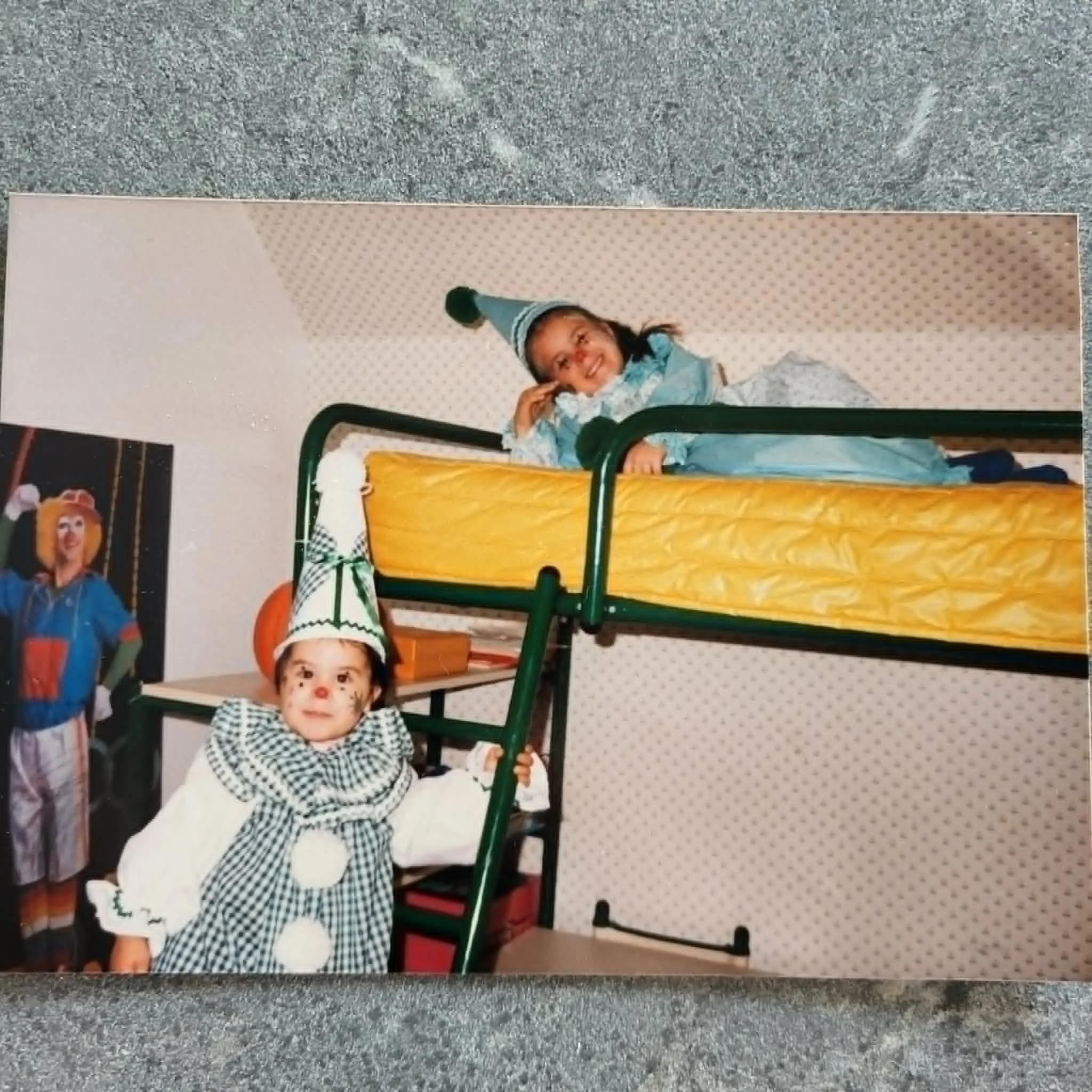 Un groupe d'enfants déguisés pour une fête, avec un enfant en clown et un autre en costume de clown, dans une pièce avec un décor de fête.