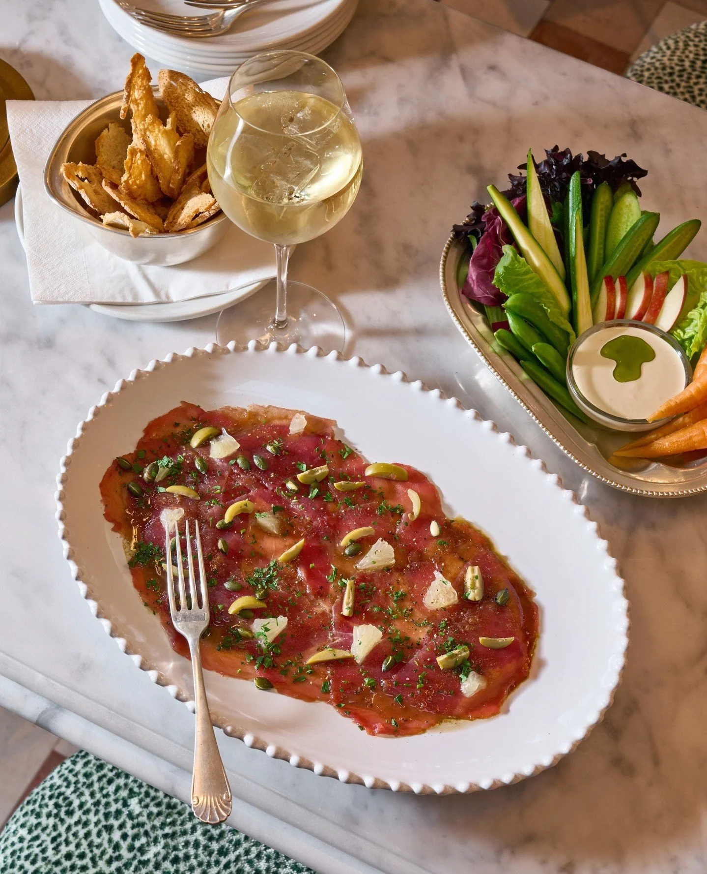 A classic that goes particularly well with a chilled glass of white. Tuna Carpaccio. Tuna, green olives, tonnato, chives.⁠
⁠
#tunacarpaccio #leparc #polofields