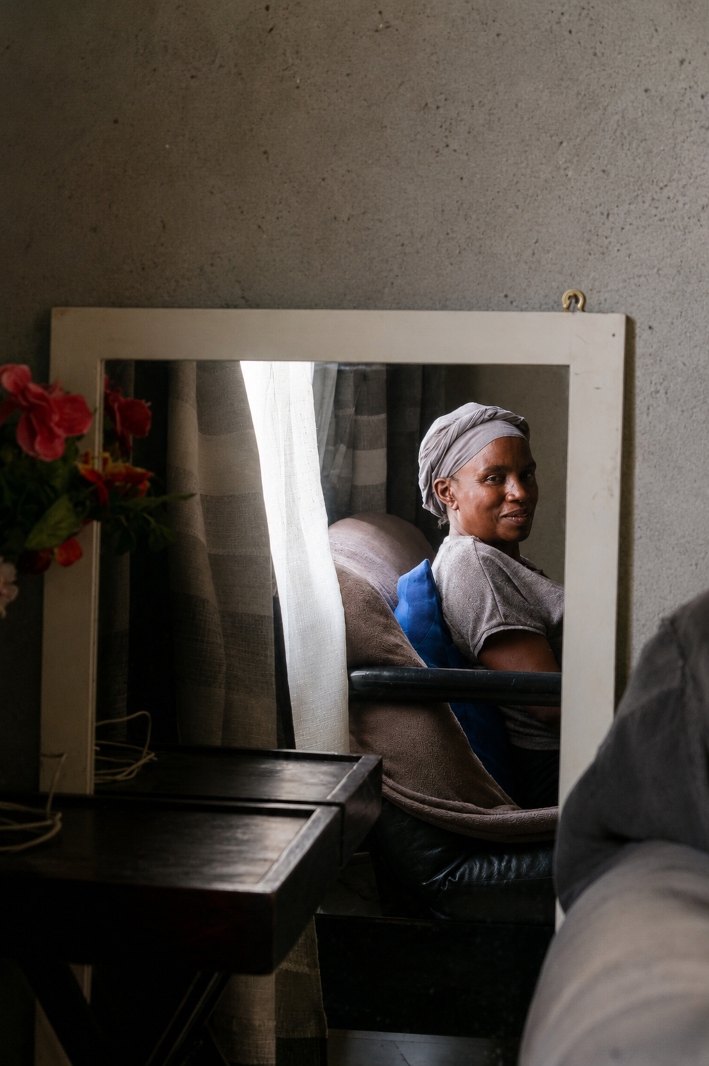 Gertrude is seen inside her living room where she likes to keep a mirror. © Angela Jimu