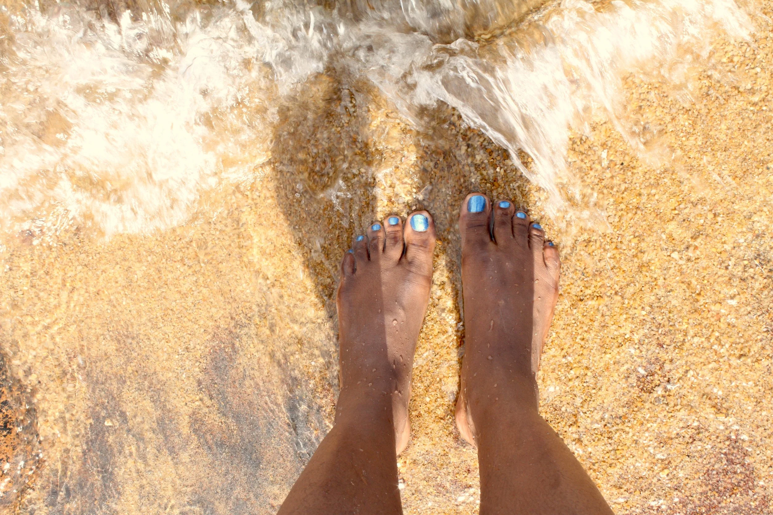Feet stepping into Lake Malawi for the first time.