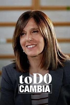 Mujer sonriente con cabello castaño oscuro y blusa a rayas, fondo de líneas horizontales, texto que dice 'to DO CAMBIA'.