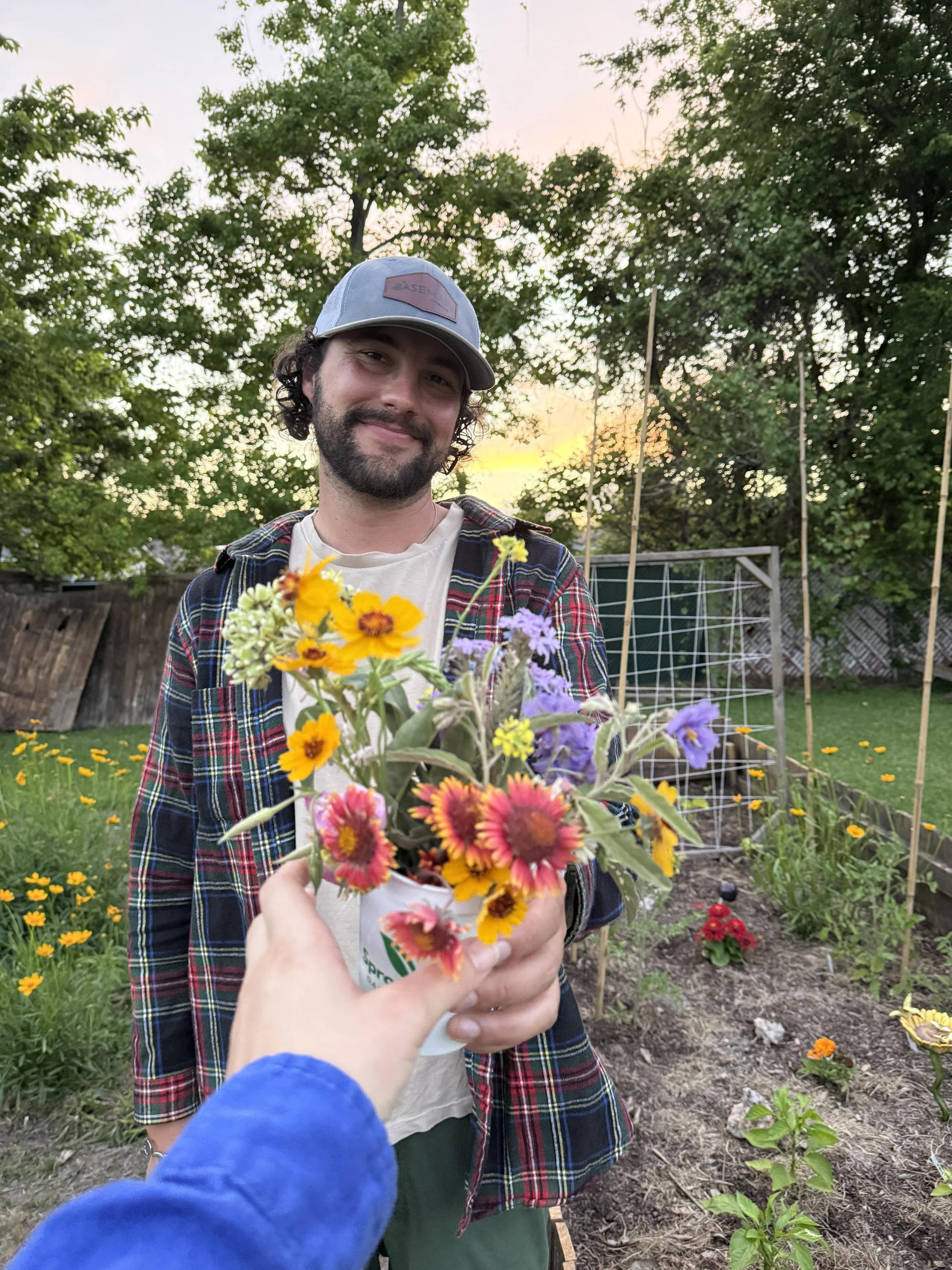 Devin in the garden with a colorful bouquet of flowers.