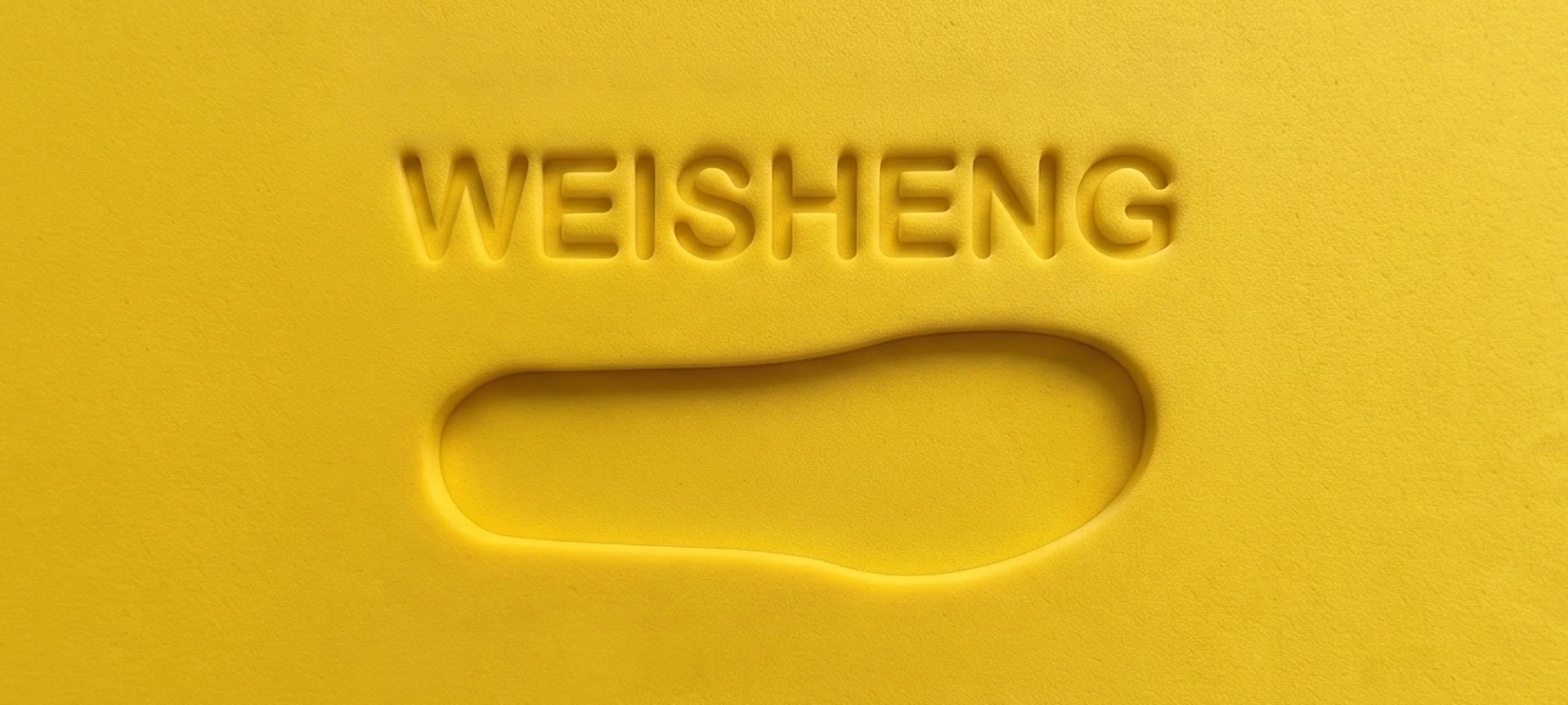 Close-up of a yellow textured surface with the word 'WEISHENG' embossed above a slot or hole.