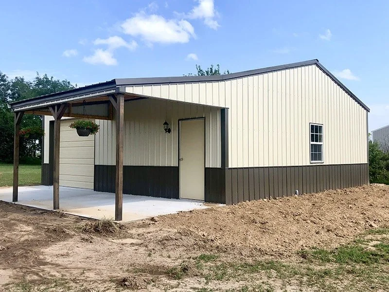 A metal shed or small building with a sloped roof, beige and dark gray exterior, and a small porch with a hanging flower pot.