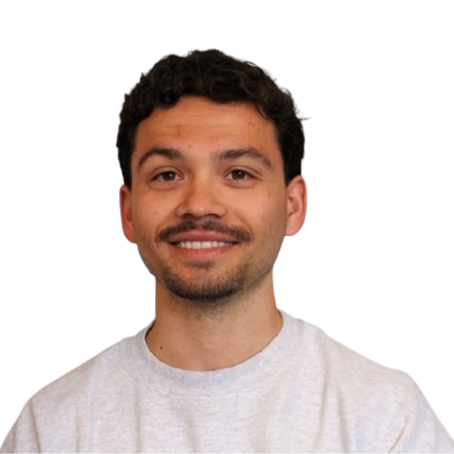 Headshot of a young man with dark, curly hair, light facial hair, and wearing a light gray sweatshirt, smiling at the camera.