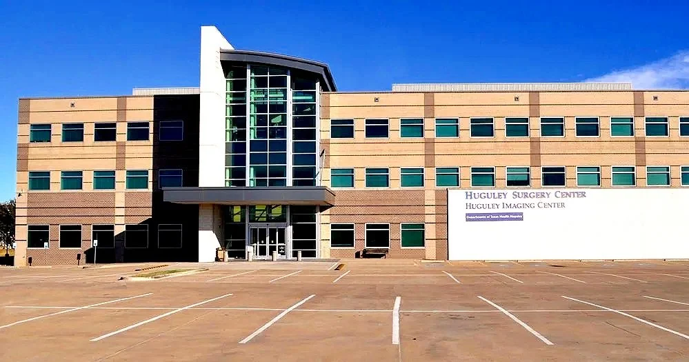 Empty parking lot in front of a modern hospital building.