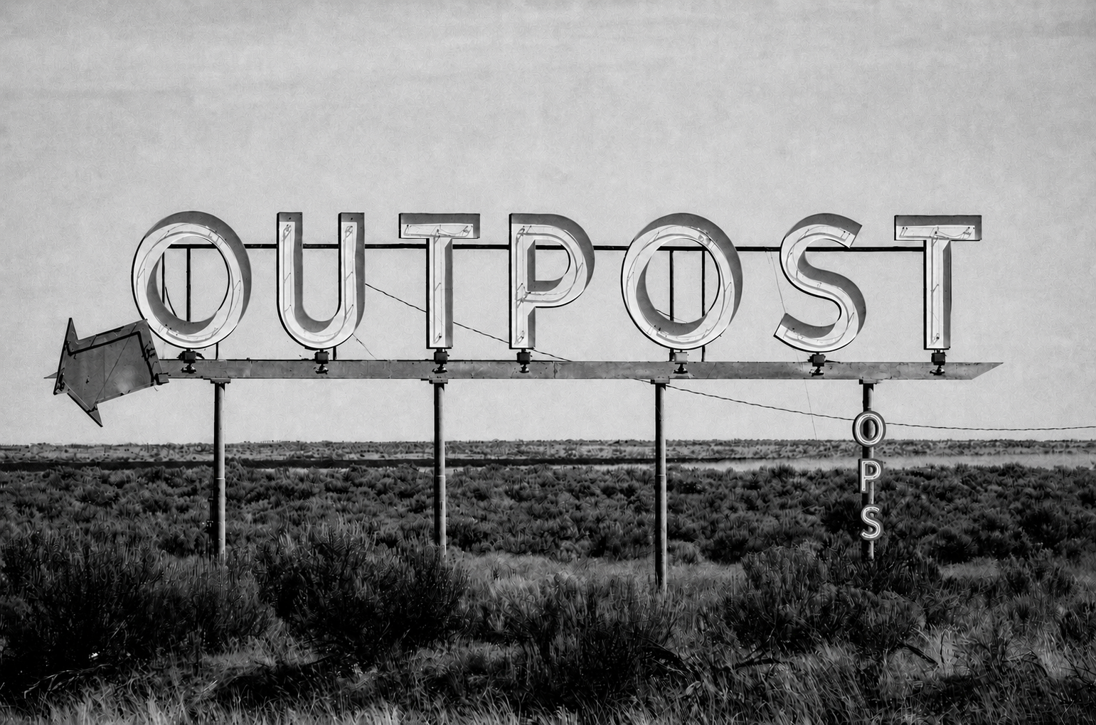 Outpost Ops sign with arrow in desert
