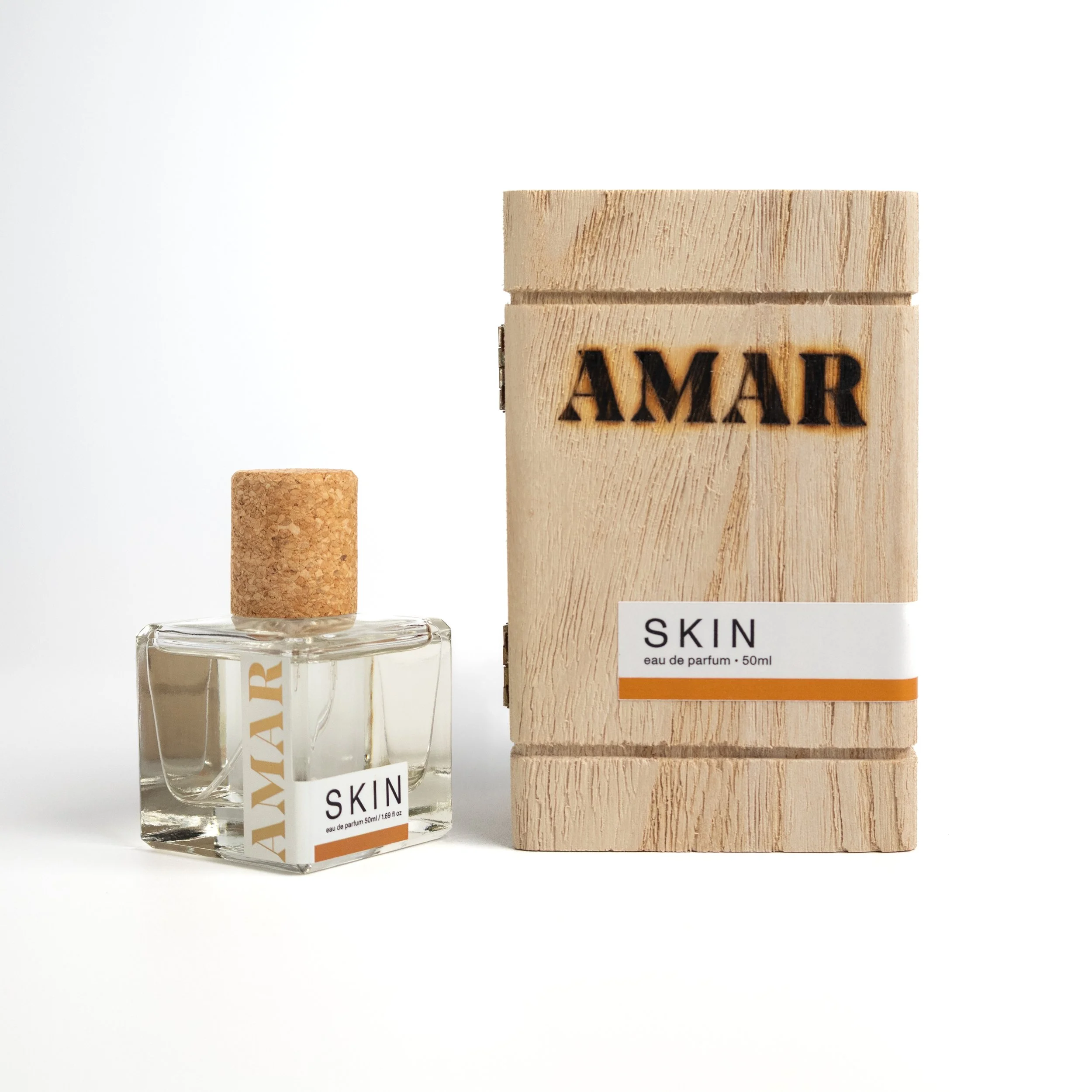 AMAR SKIN Eau de Parfum bottle standing beside its wooden box, engraved with the AMAR name