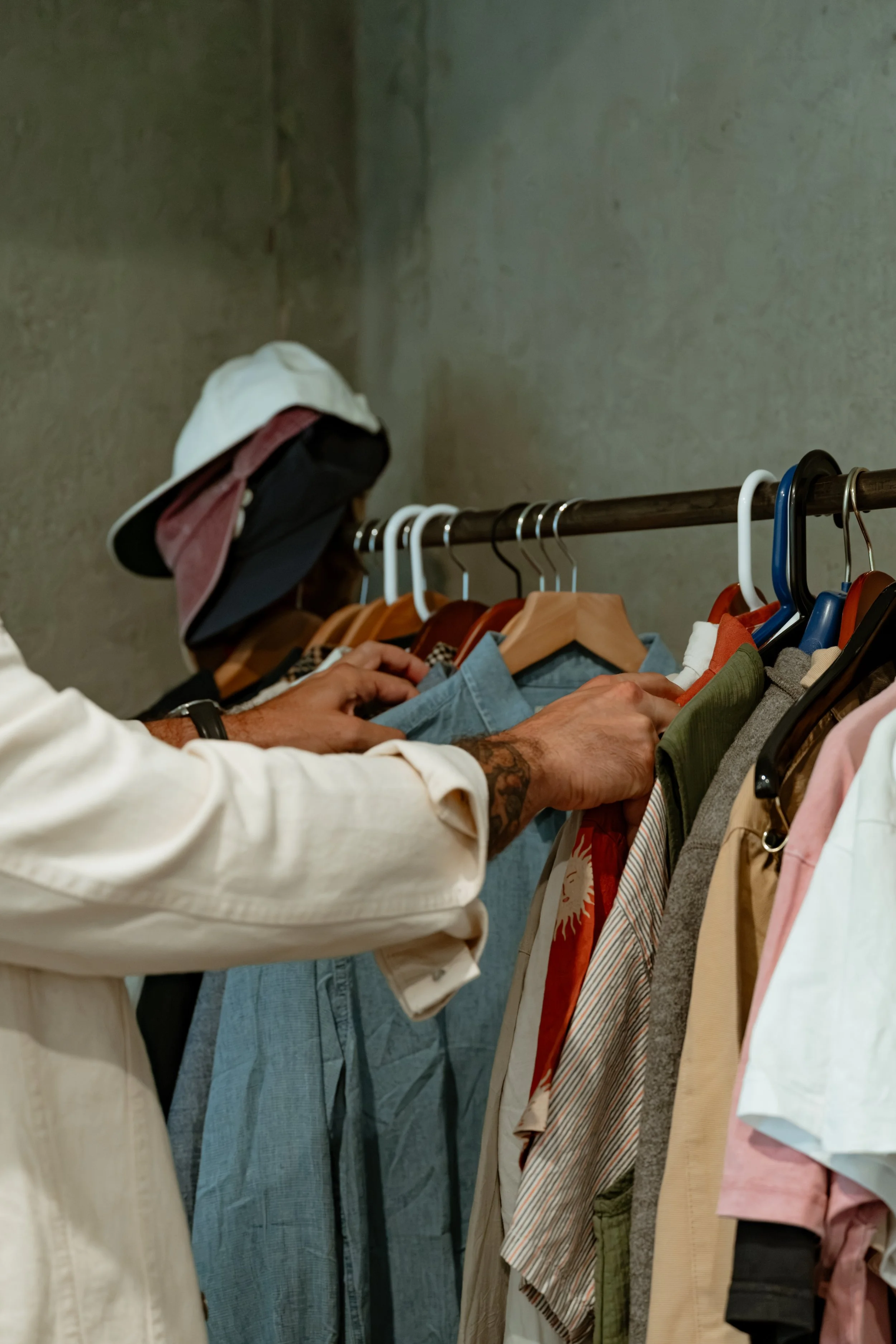 A man browsing his personal wardrobe to find an effortless outfit for the day ahead.