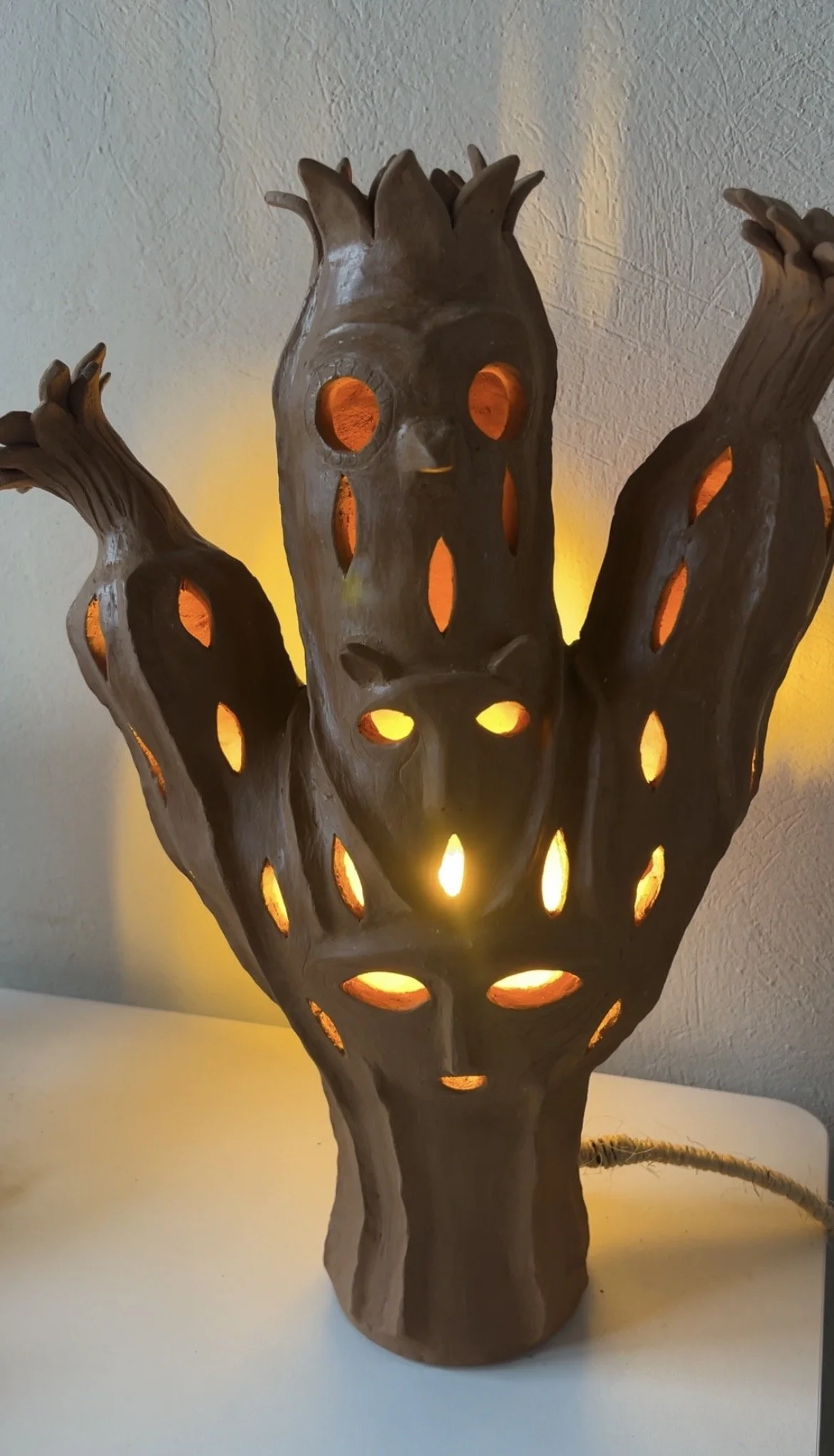 Earthenware lamp resembling a totem with animal faces and cactus arms