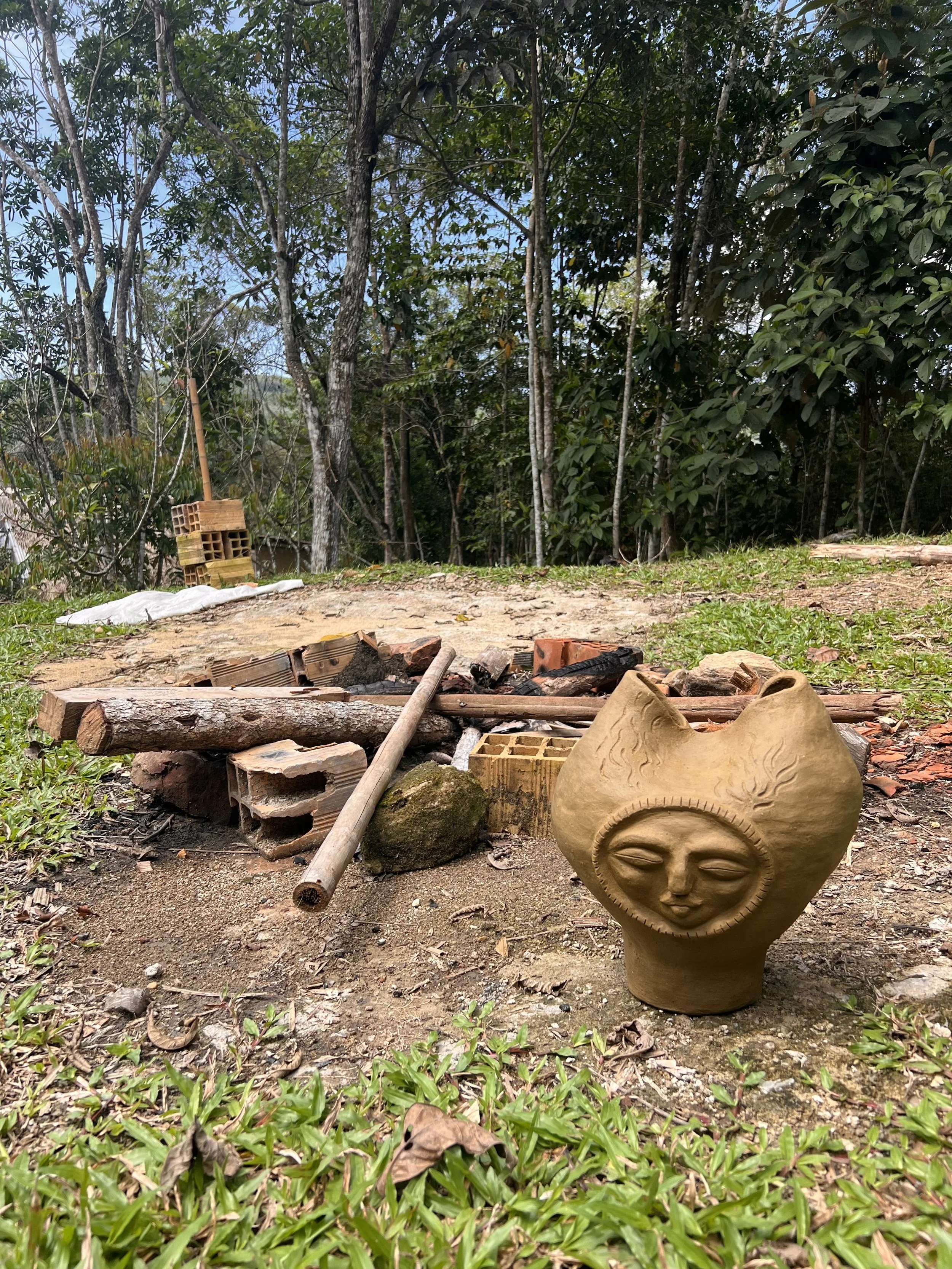 A ceramic piece sits next to a fire yet to be built
