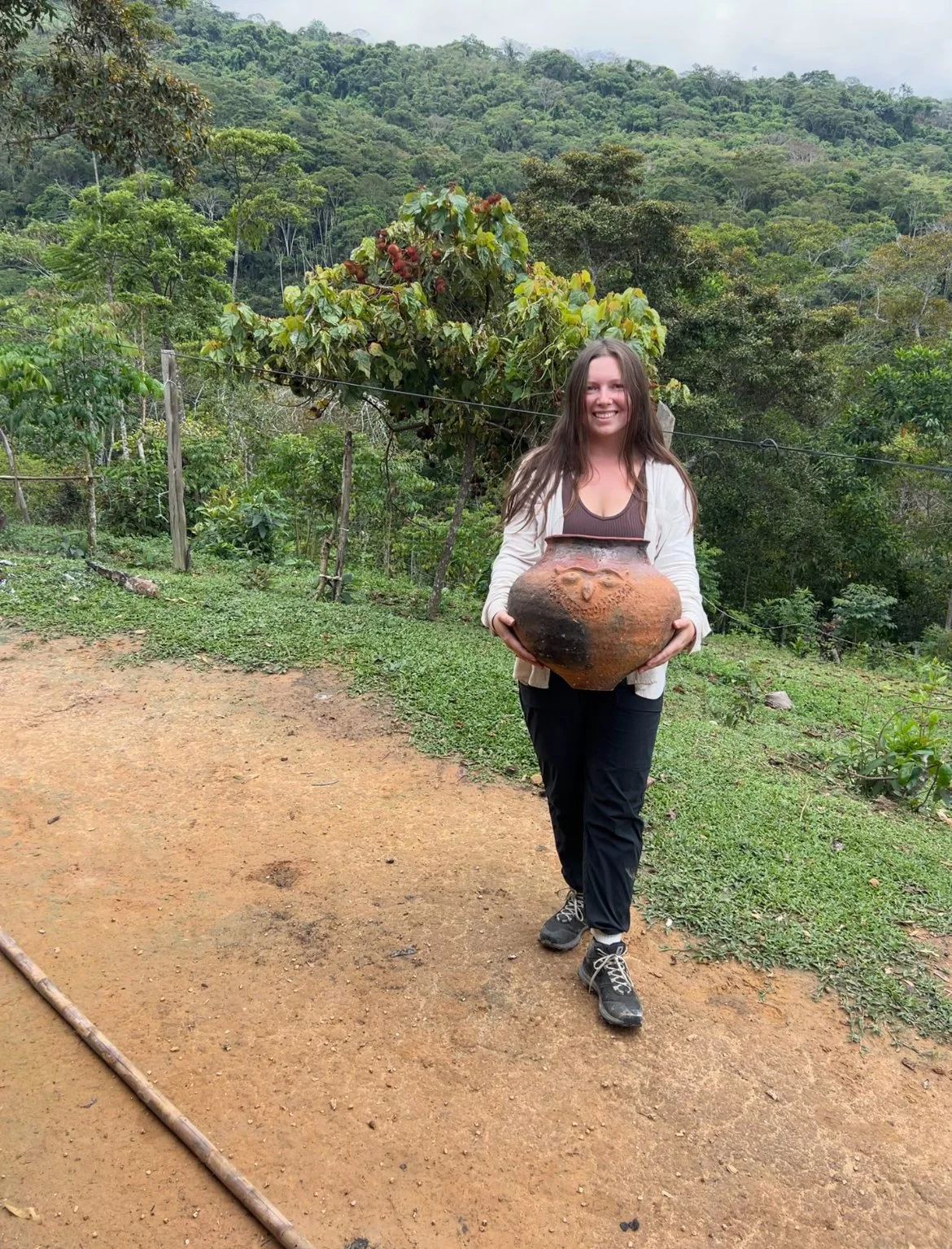 Emily holds a finished tinaja pot in the Amazon jungle
