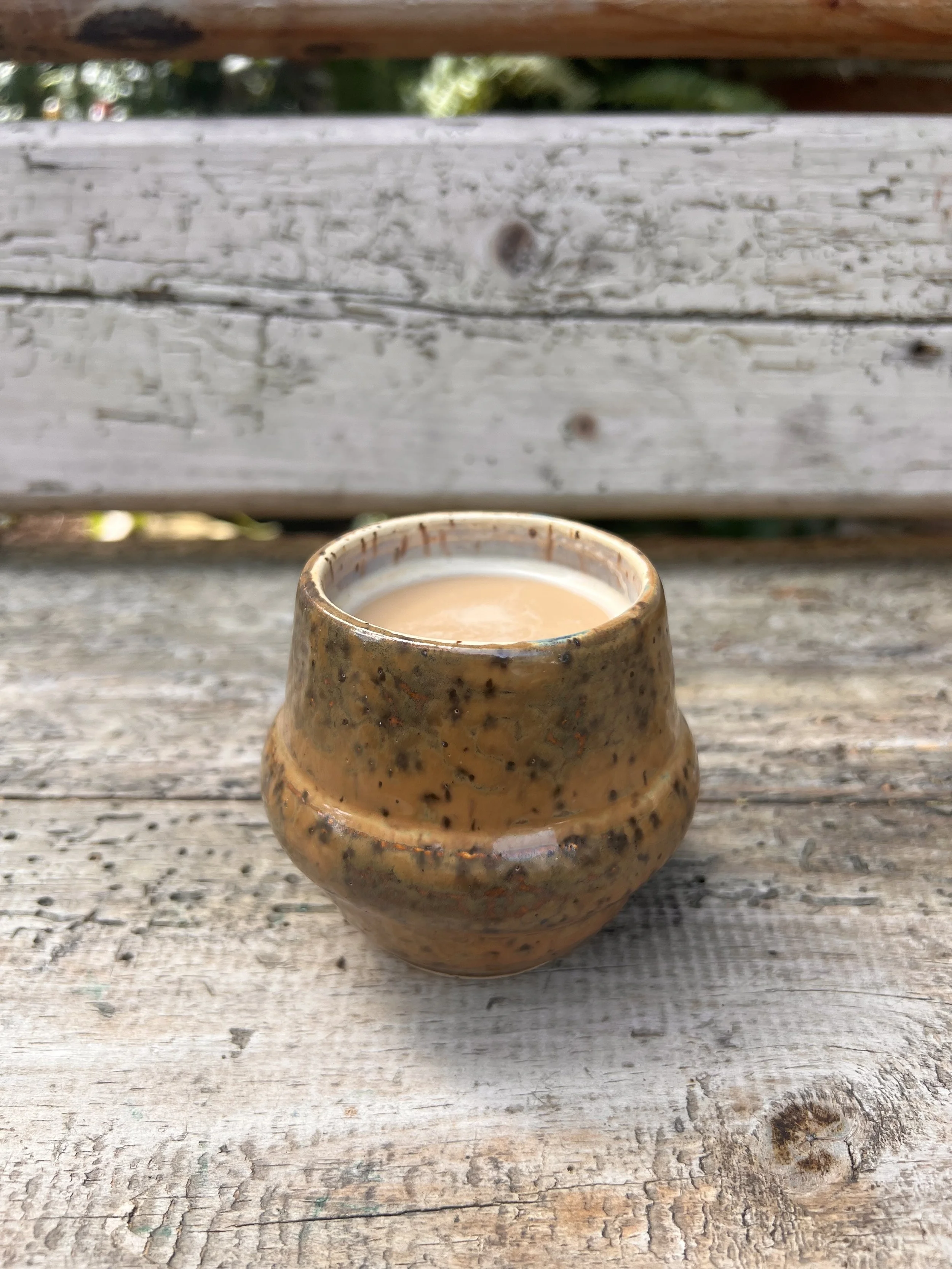 A small handle-free flat white cup with a speckled finish