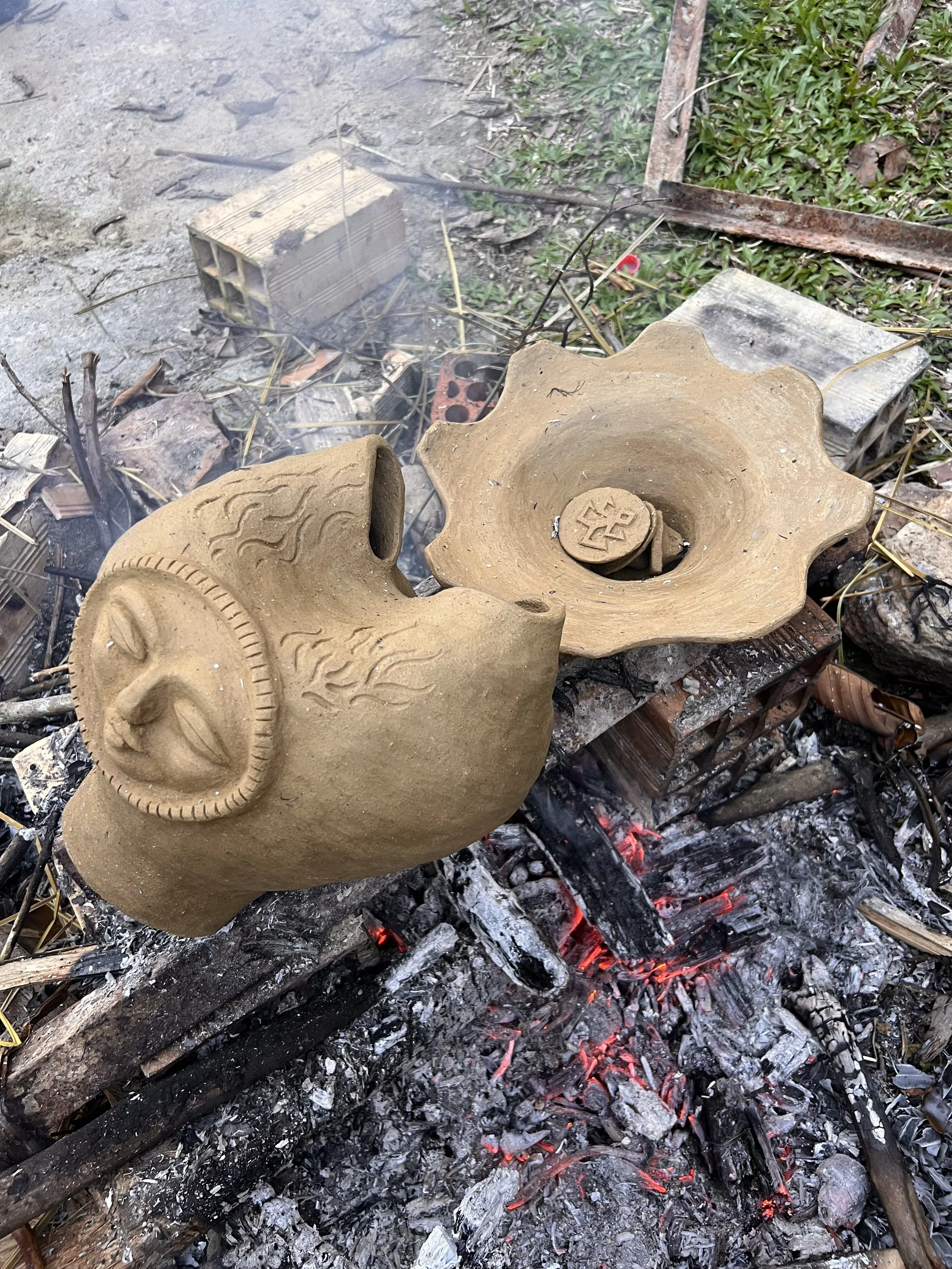 Clay pieces warm up in a bonfire