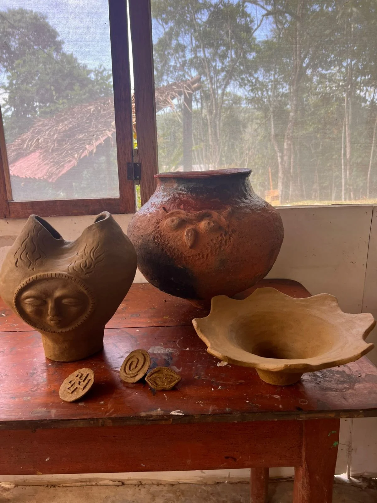 One fired piece sits among raw clay pieces