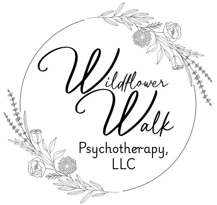 A black and white logo for Wildflower Walk Psychotherapy LLC featuring floral illustrations surrounding the text.