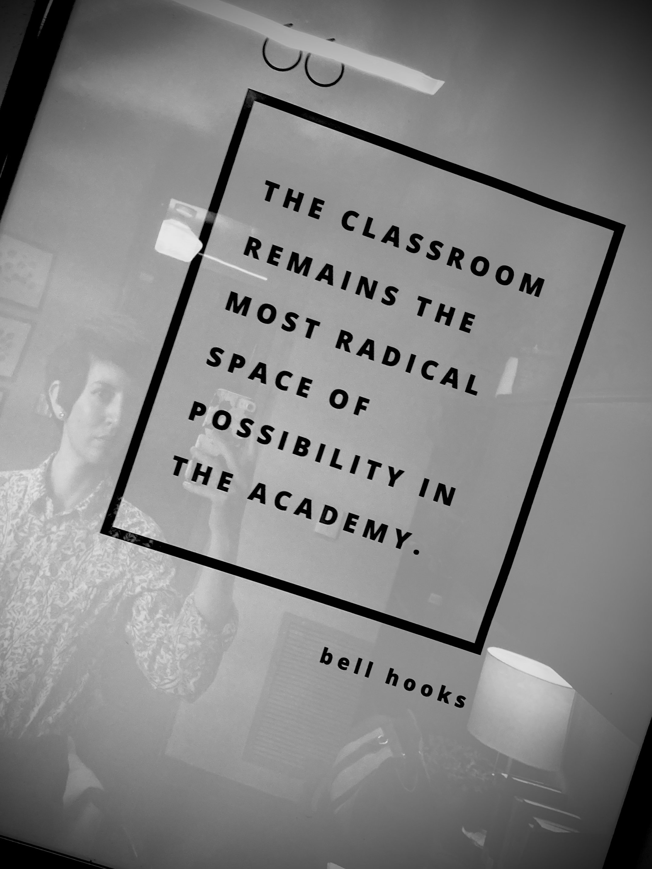 black and white photo of a poster that reads "The classroom remains the most radical space of possibility in the academy. -bell hooks"