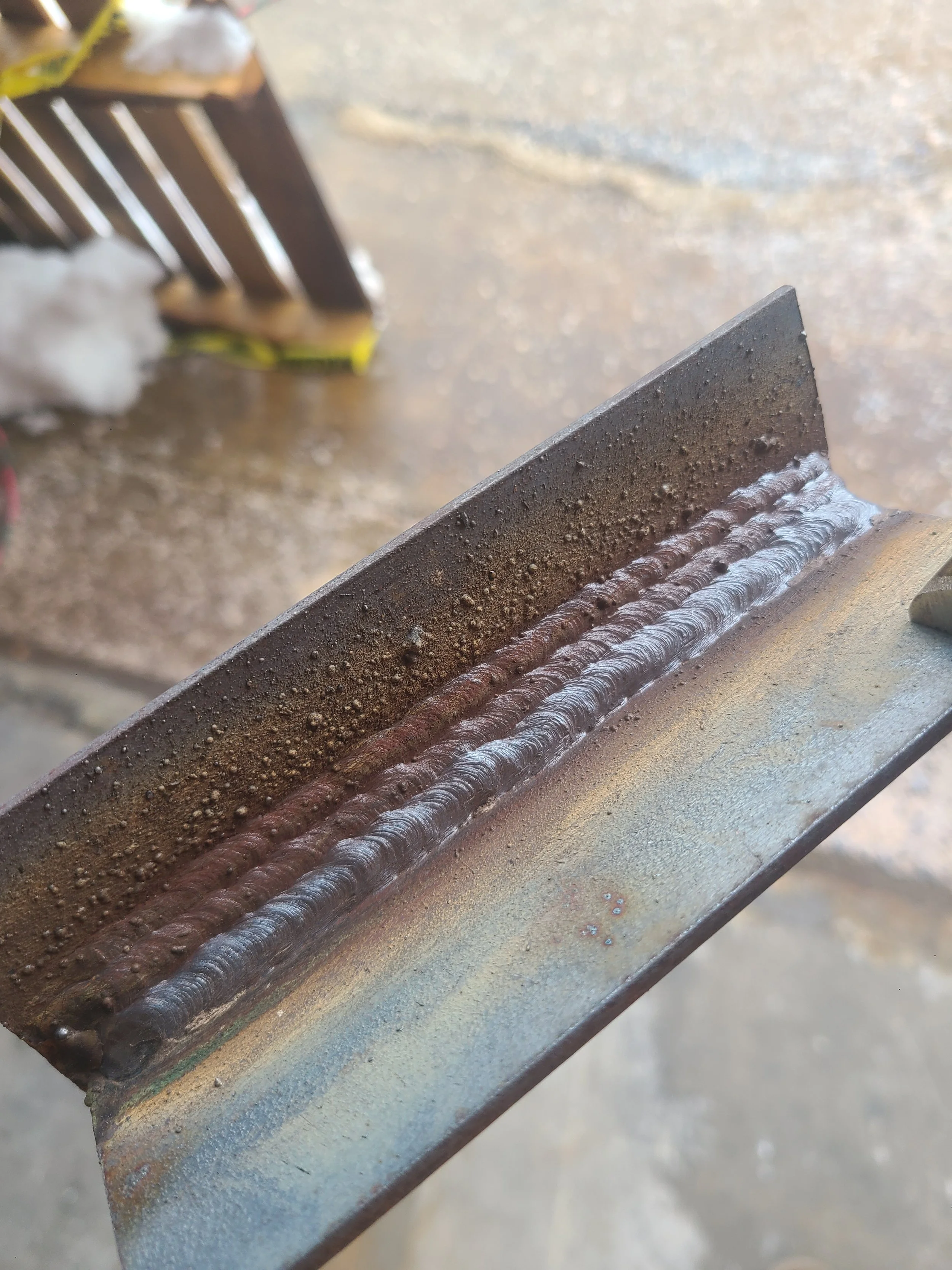 Shielded Metal Arc Welding (SMAW) utilizing a 7018 electrode on 1/8-inch carbon steel.