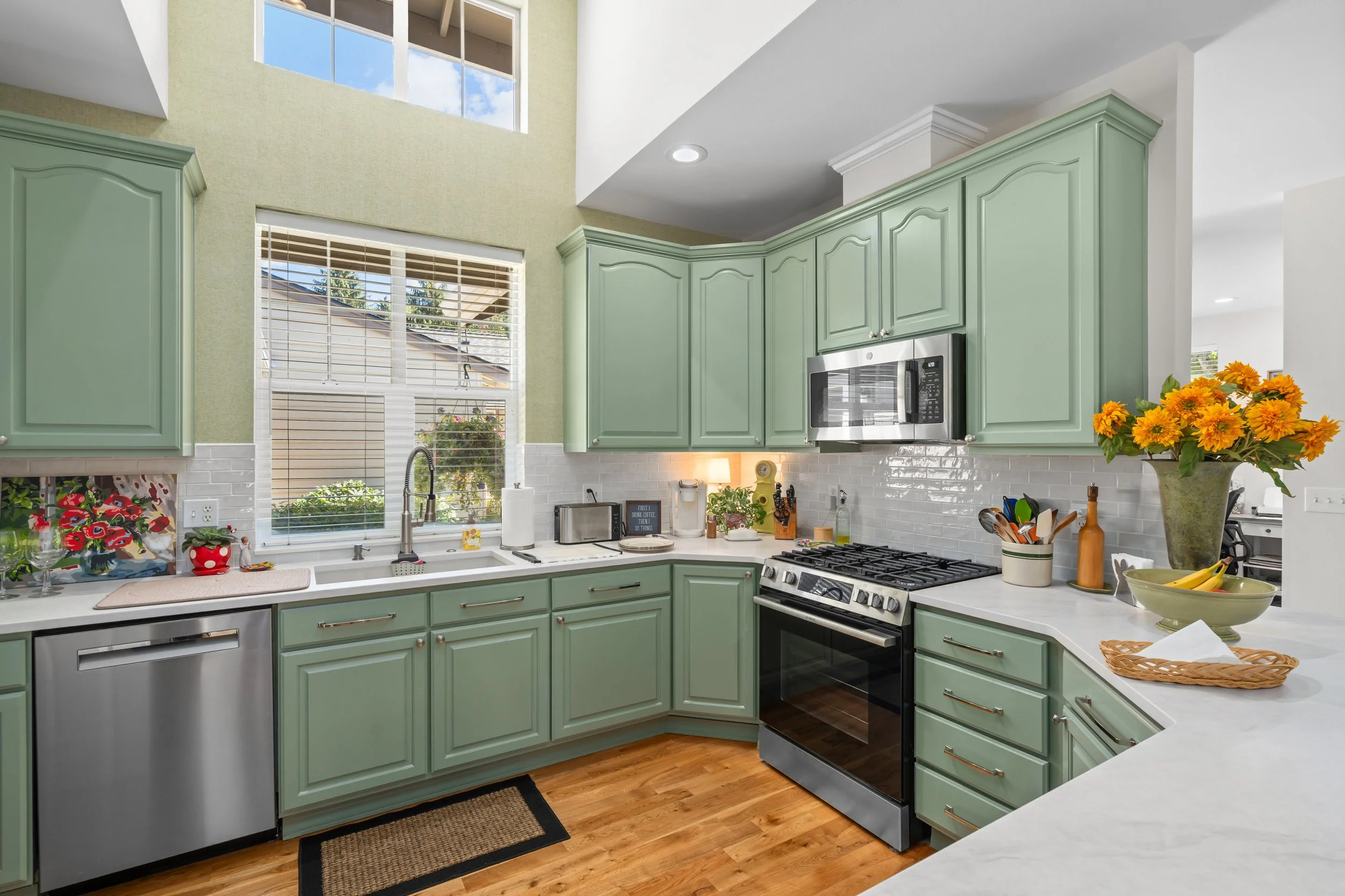 The Mollie House Transformation — remodeled kitchen with green shaker cabinets, stainless appliances and quartz island, Redmond interior remodel