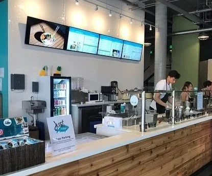 Restaurant retail fit-out completed by F&M Construction & Remodeling at Just Poké in Bellevue, WA, featuring a custom service counter, commercial millwork, and modern restaurant construction serving Seattle and the Eastside.