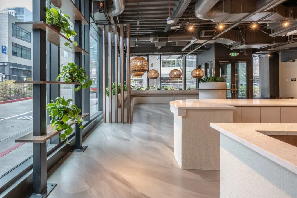 Luxury retail showroom remodel at DUXIANA in Bellevue, WA, featuring a custom wood reception desk, illuminated feature wall, premium product displays, and contemporary finishes completed by F&M Construction & Remodeling.