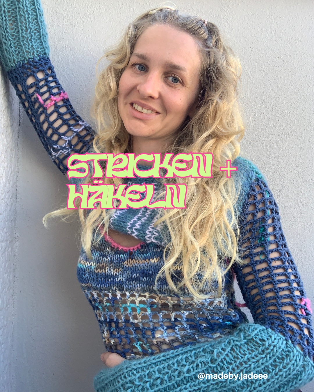Frau trägt einen bunten gestrickten Pullover und Ärmel, steht vor einer weißen Wand, lächelt, mit langen blonden Locken, Text "Stickend + Häkelnd" auf der Bildmitte, Wasserzeichen @madeby.jadeee.