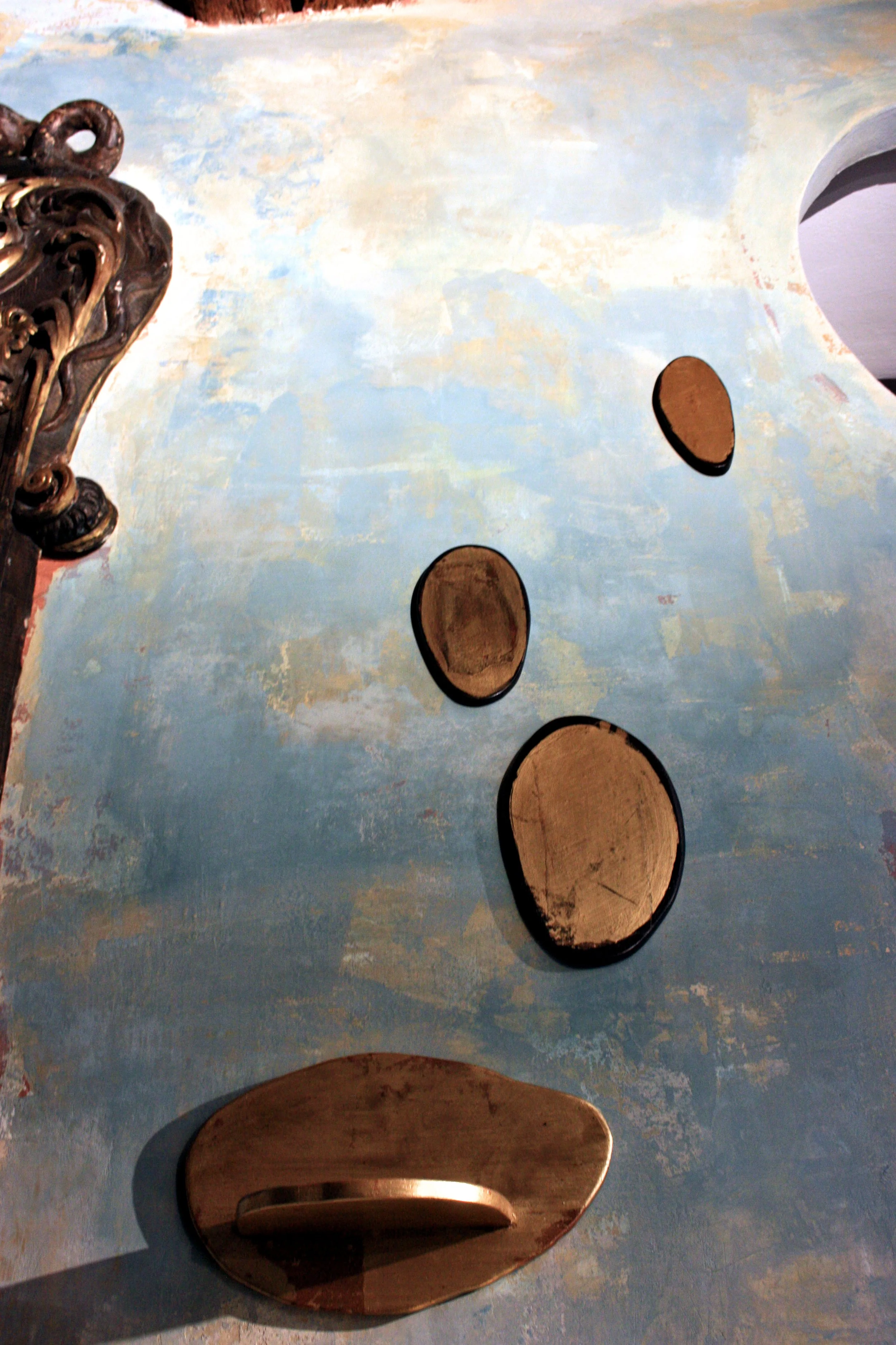 Elementi in compensato di betulla sagomati e rivestiti a mano in foglia oro, ispirati alla pratica dello stone balancing.