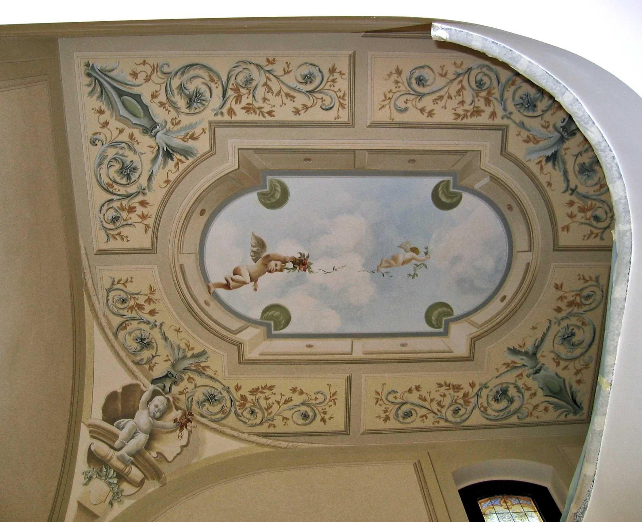Soffitto decorato con una composizione pittorica classica raffigurante putti, motivi floreali e volute ornamentali