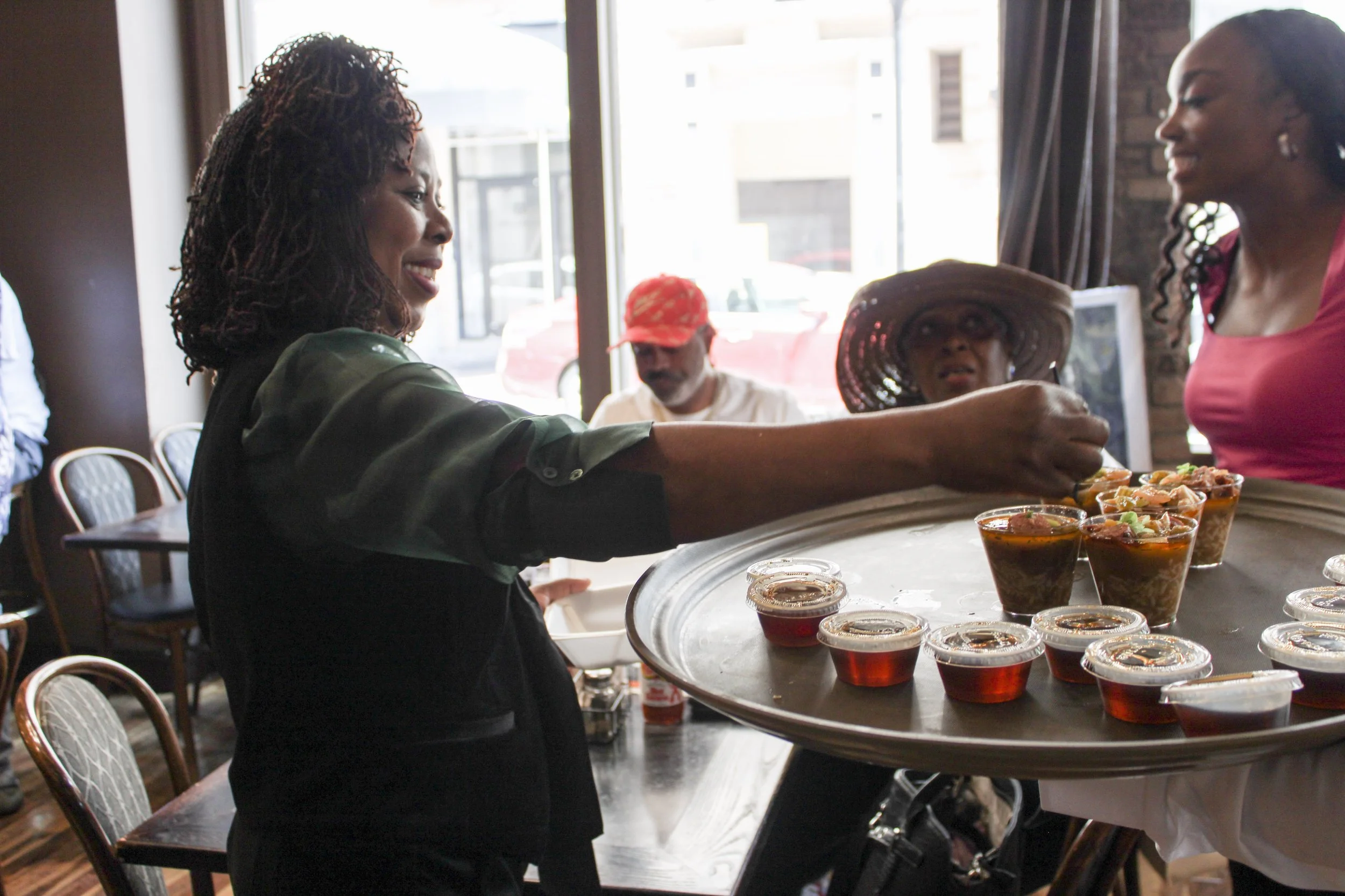 A woman serving appetizers at a buffet table in a restaurant.