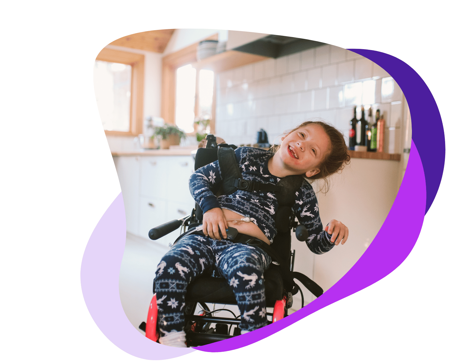 Jeune fille souriante en fauteuil roulant dans une cuisine lumineuse.