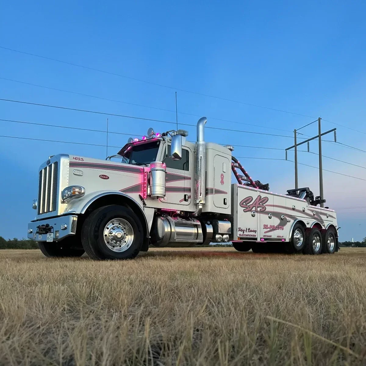 White SAS Road Solutions heavy-duty tow truck parked in a field