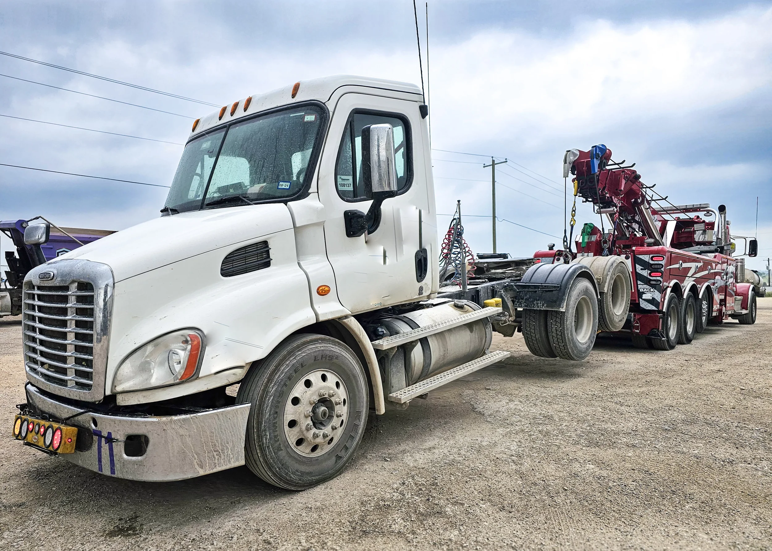 White SAS Road Solutions tow truck parked at a towing yard in Central Texas