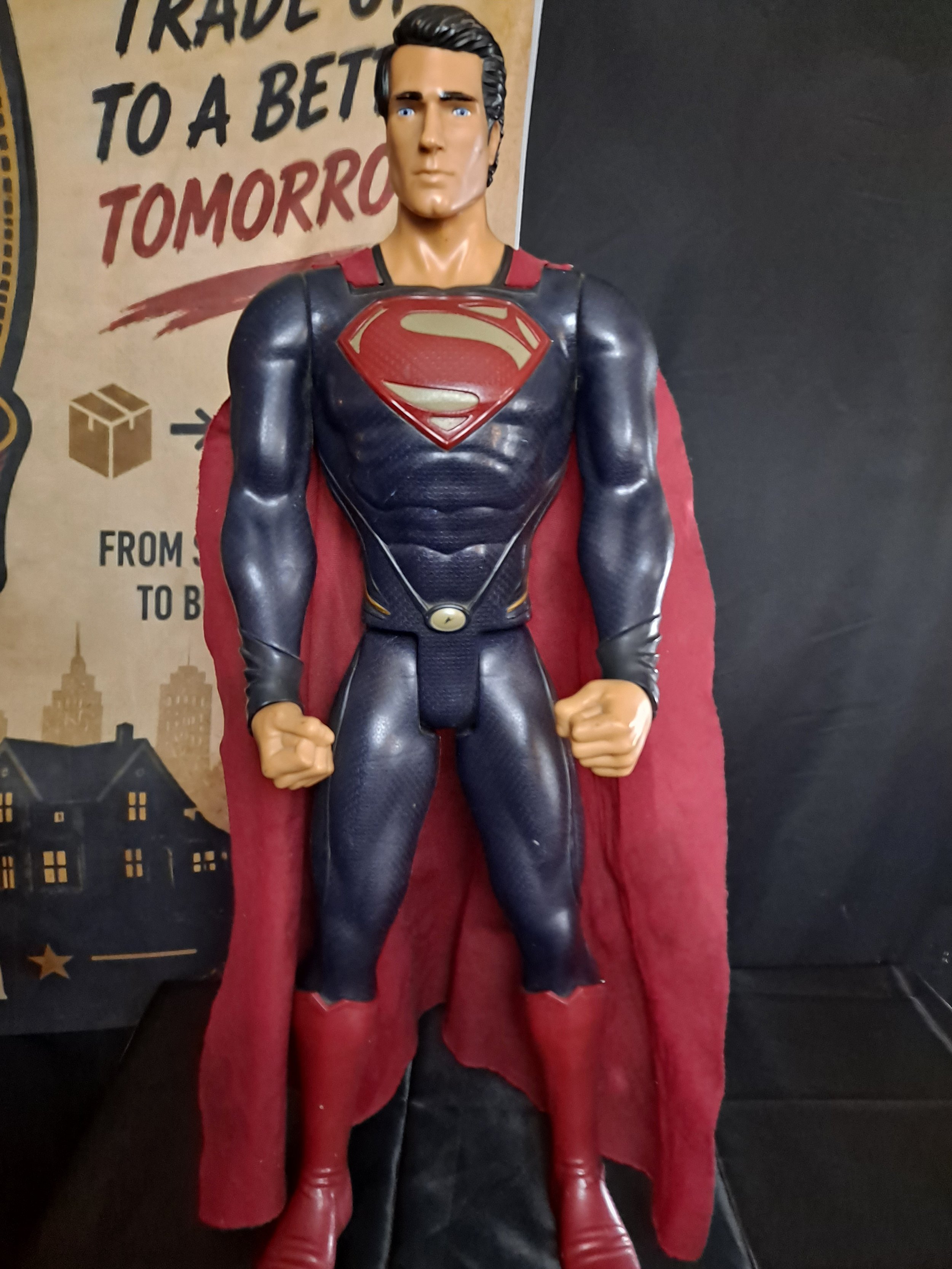 Figure of Superman superhero action figure with a red cape, blue suit, and a large "S" emblem on the chest, standing with clenched fists.