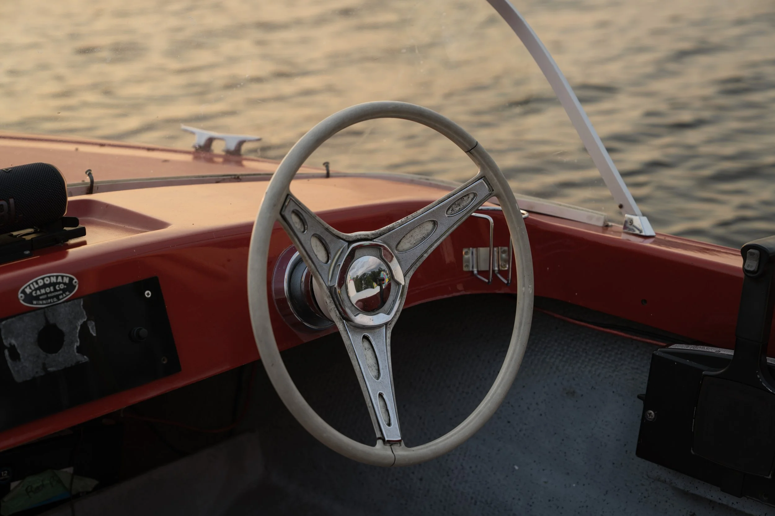 White steering wheel and Kildonan Canoe Co. builder's plate inside a vintage boat