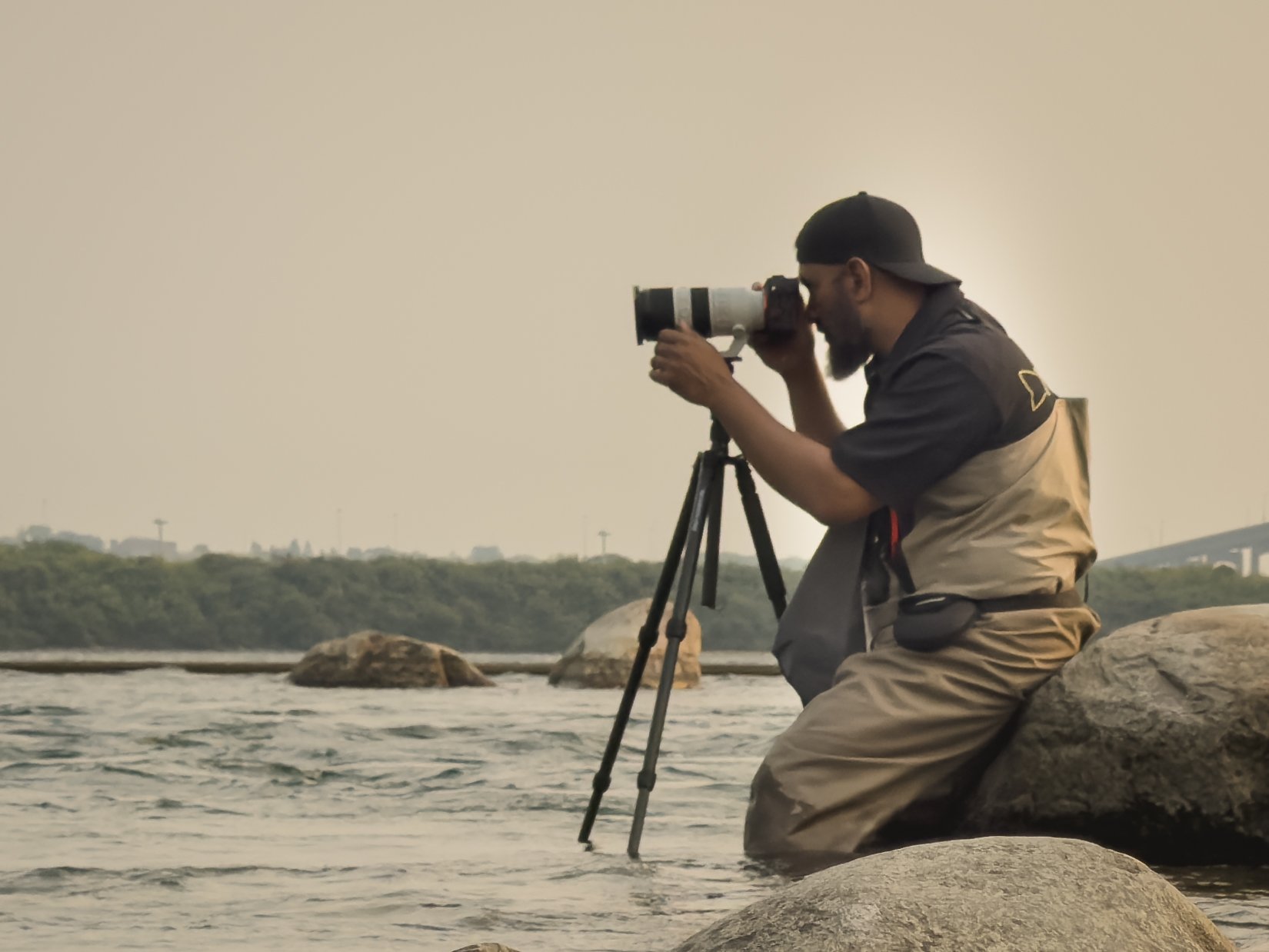 Portrait of Zaheer, outdoor and fishing photographer, in waders by the river