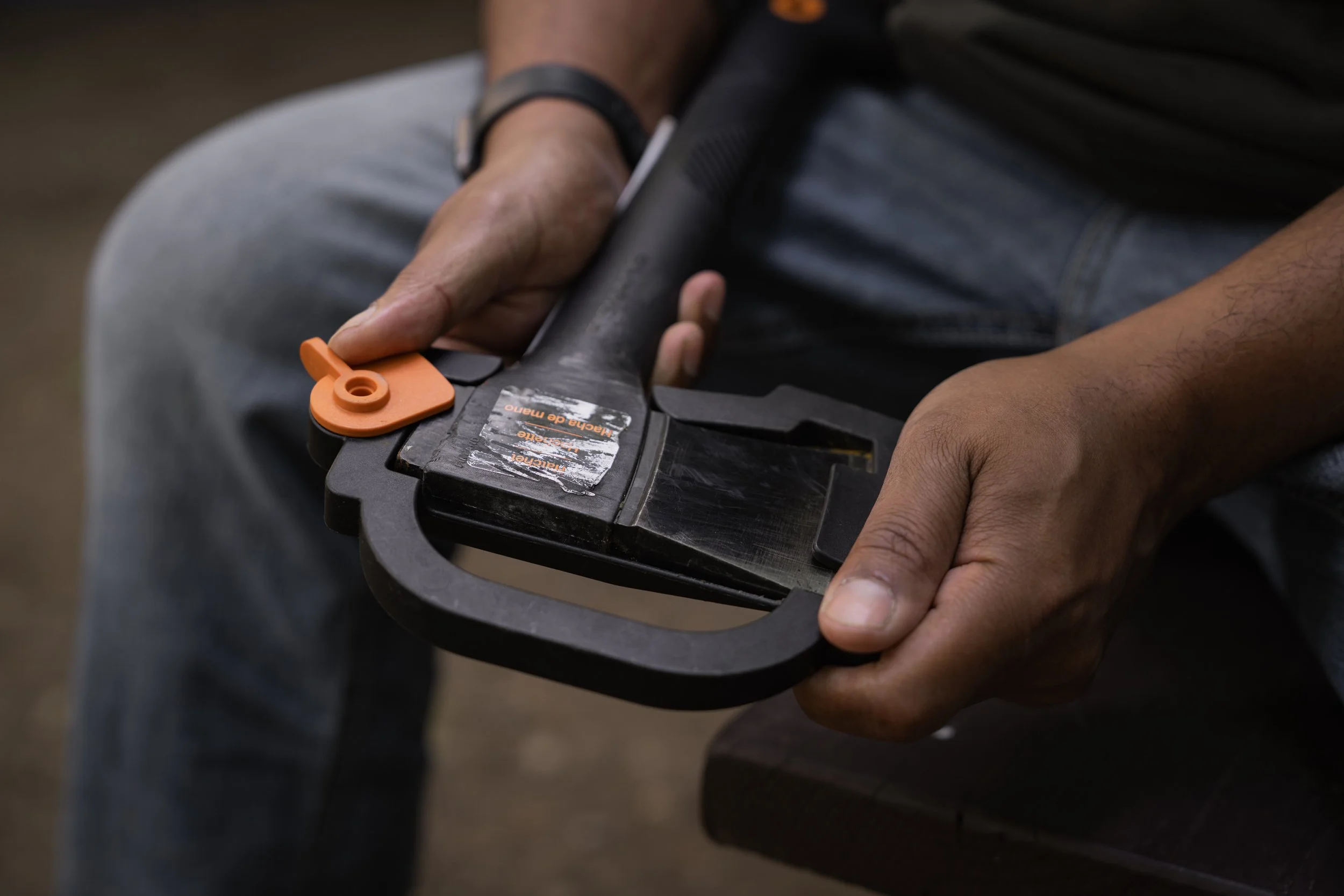 Close-up of hands holding a black Fiskar's axe with orange accents
