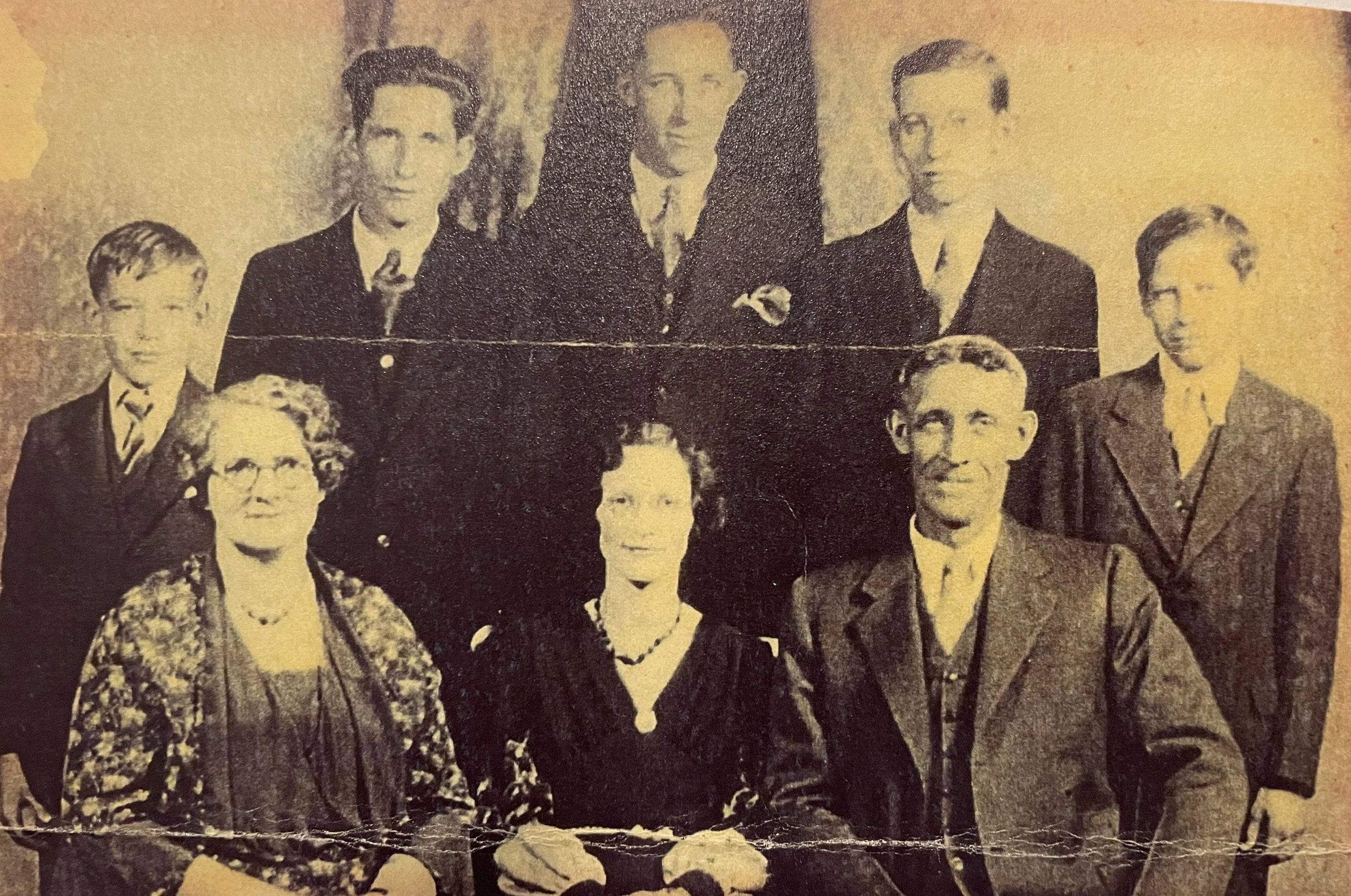 Black and white vintage photograph of a group of mostly women and some men dressed in formal clothing, posing for a group portrait.