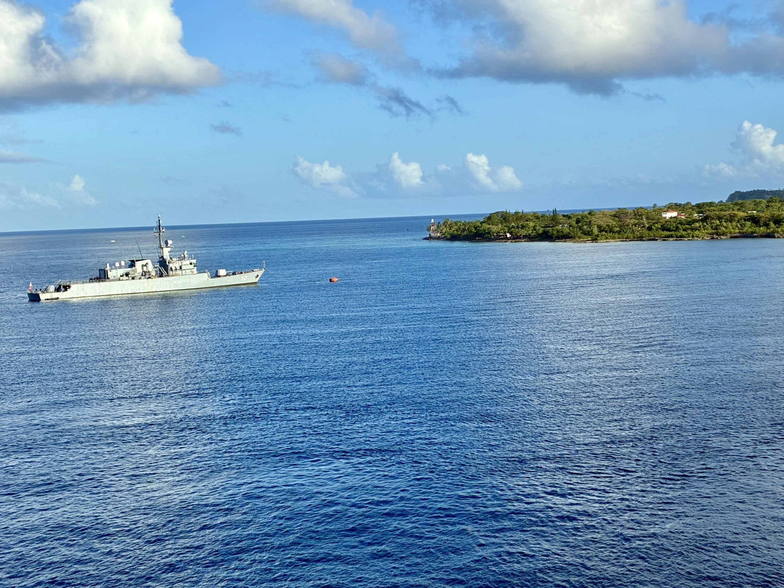 The ship at anchor off a Caribbean island.