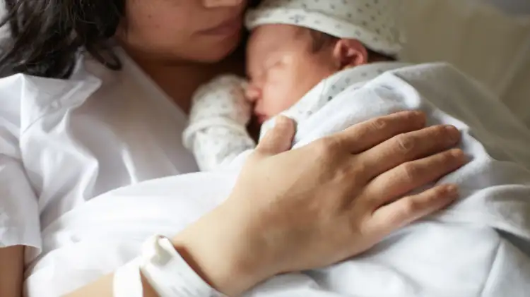 A parent holding a newborn