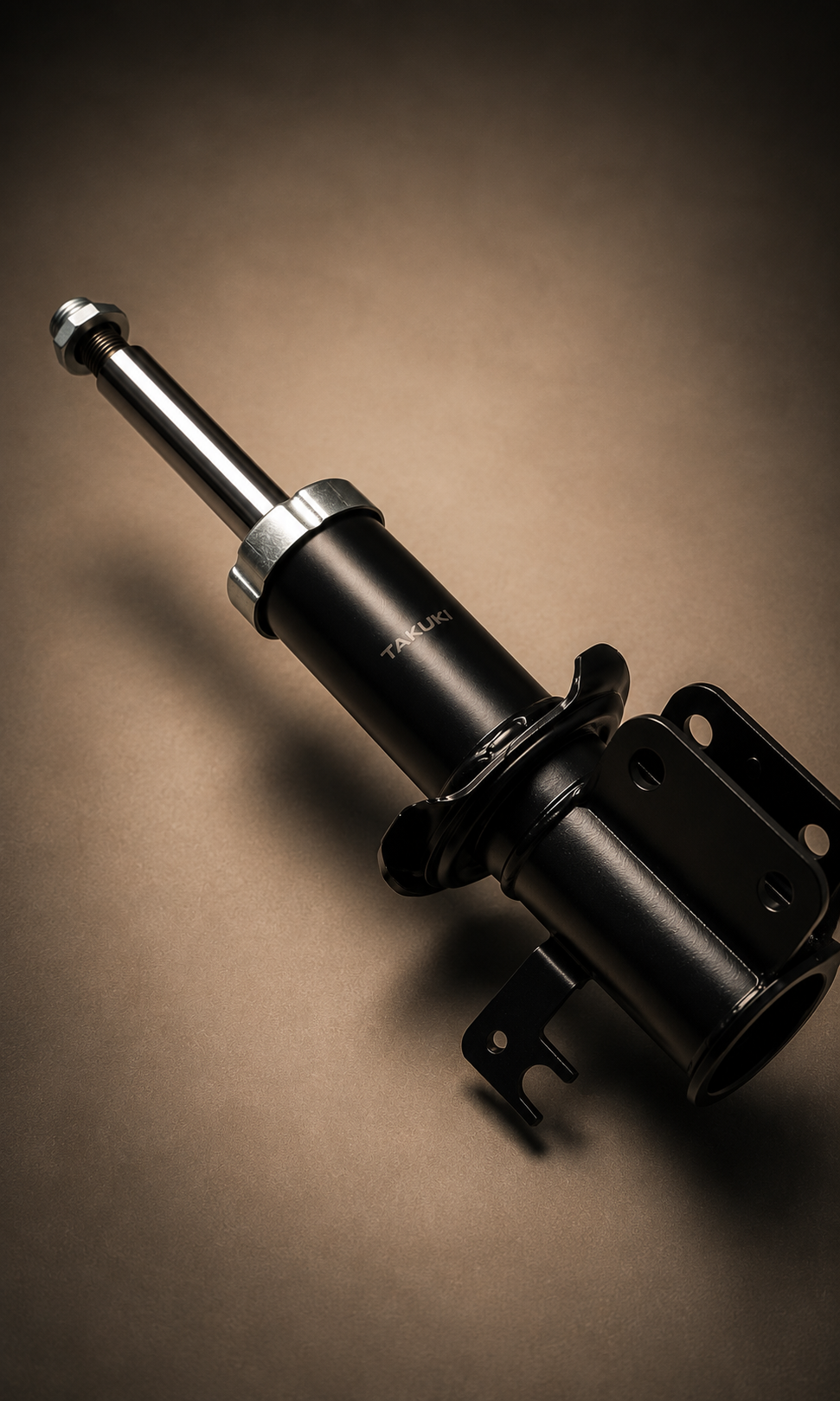 Close-up of a black shock absorber with the brand name Takuki on it, set against a brown background.