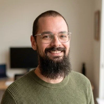 man with glasses and beard, smiling at camera
